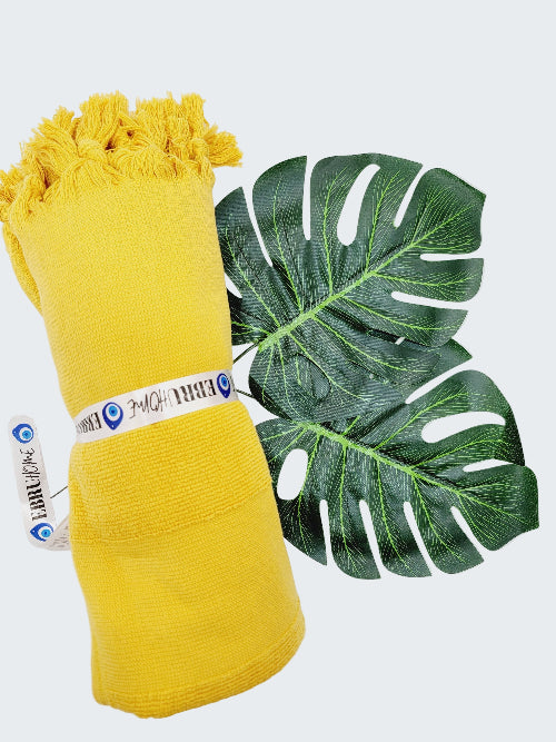Yellow fabric roll with a green leaf on a white background
