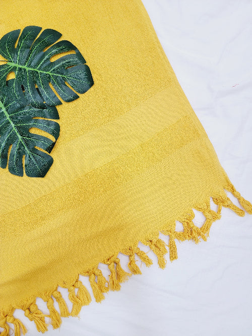 Yellow towel with green leaf design on a white background