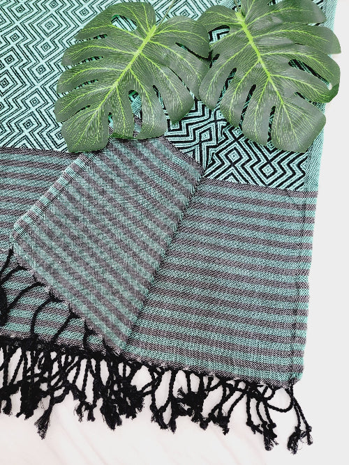 Striped towel with black fringes on a patterned background