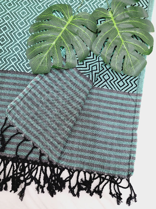 Striped towel with black tassels on a patterned surface