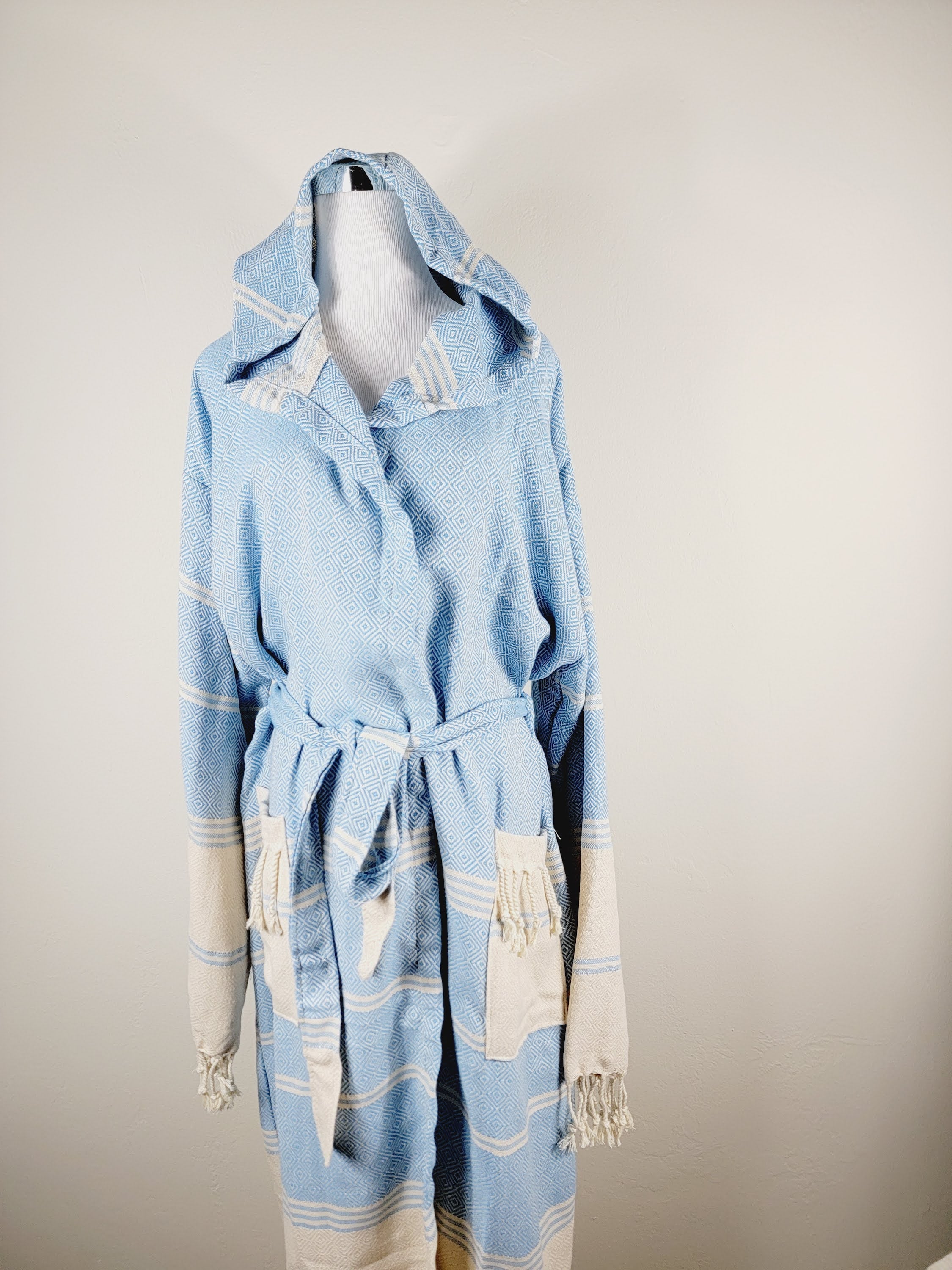 Light blue robe with white accents on a mannequin against a plain background