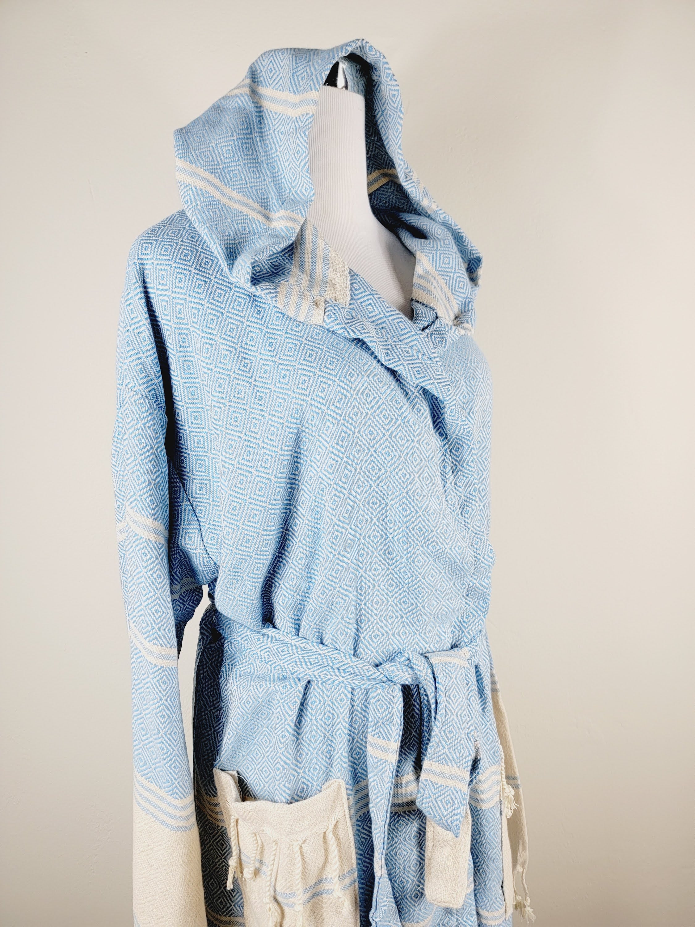 Light blue robe with white stripes on a beige background