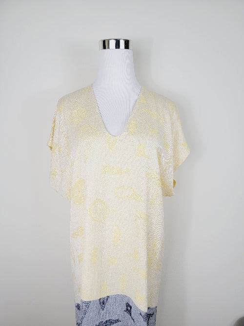 Mannequin wearing a light yellow floral patterned top on a white background