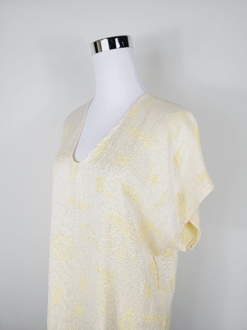 Mannequin wearing a light yellow tie-dye dress against a plain background
