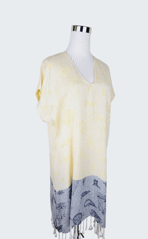 Mannequin wearing a light yellow scarf with gray fringe on a plain background