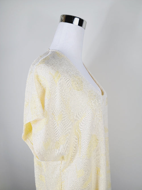 Mannequin wearing a light yellow dress with a subtle pattern on a plain background