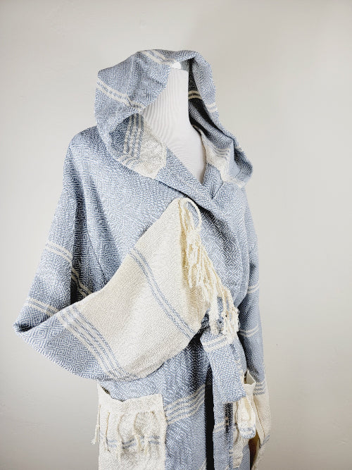 Blue and white patterned shawl with tassels on a mannequin against a plain background