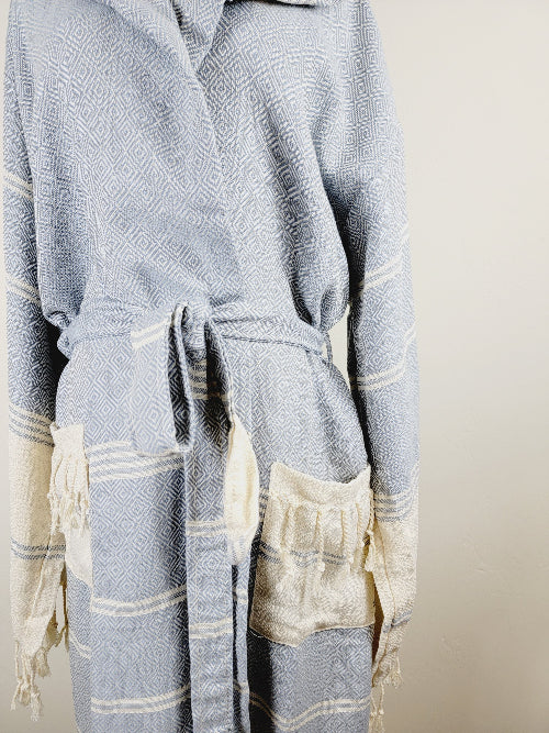 Light blue and white patterned robe with drawstring and pocket on a beige background