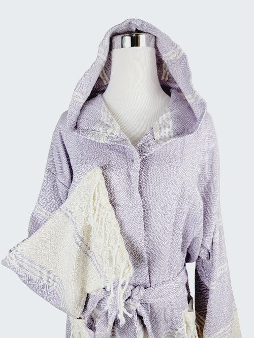 Hooded towel with purple and white stripes on a mannequin against a neutral background