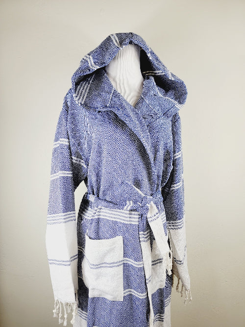 Blue and white striped hooded towel on a mannequin against a beige background