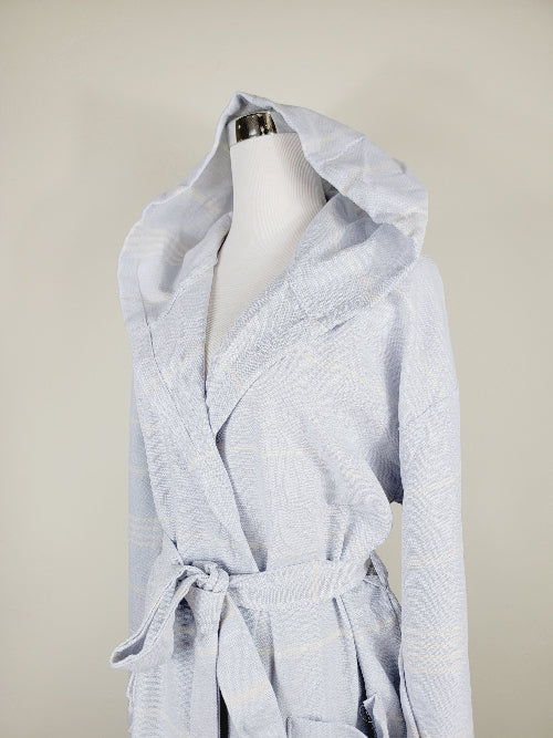 Light blue hooded robe on a mannequin against a beige background