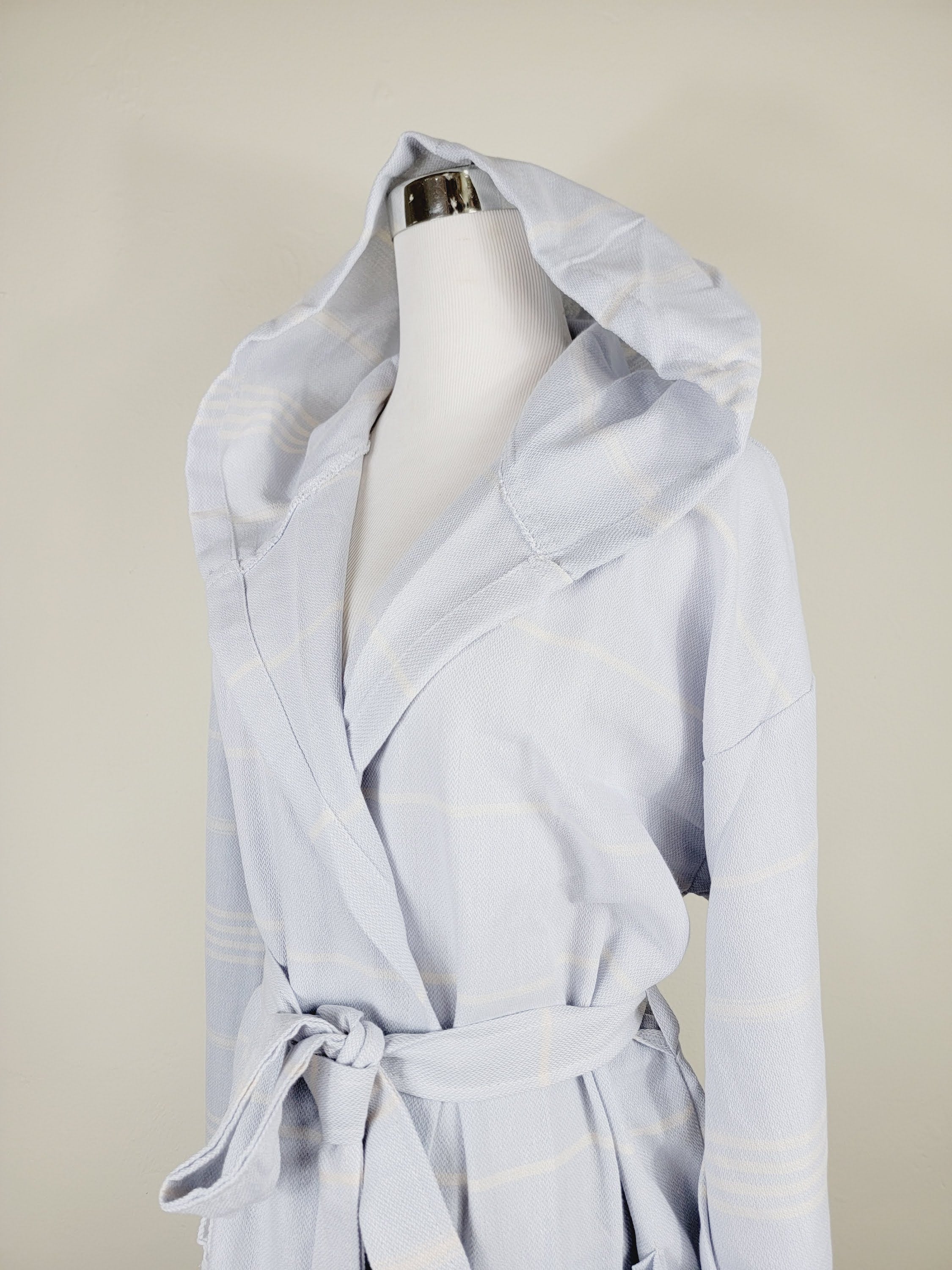 Light blue robe on a mannequin against a beige background