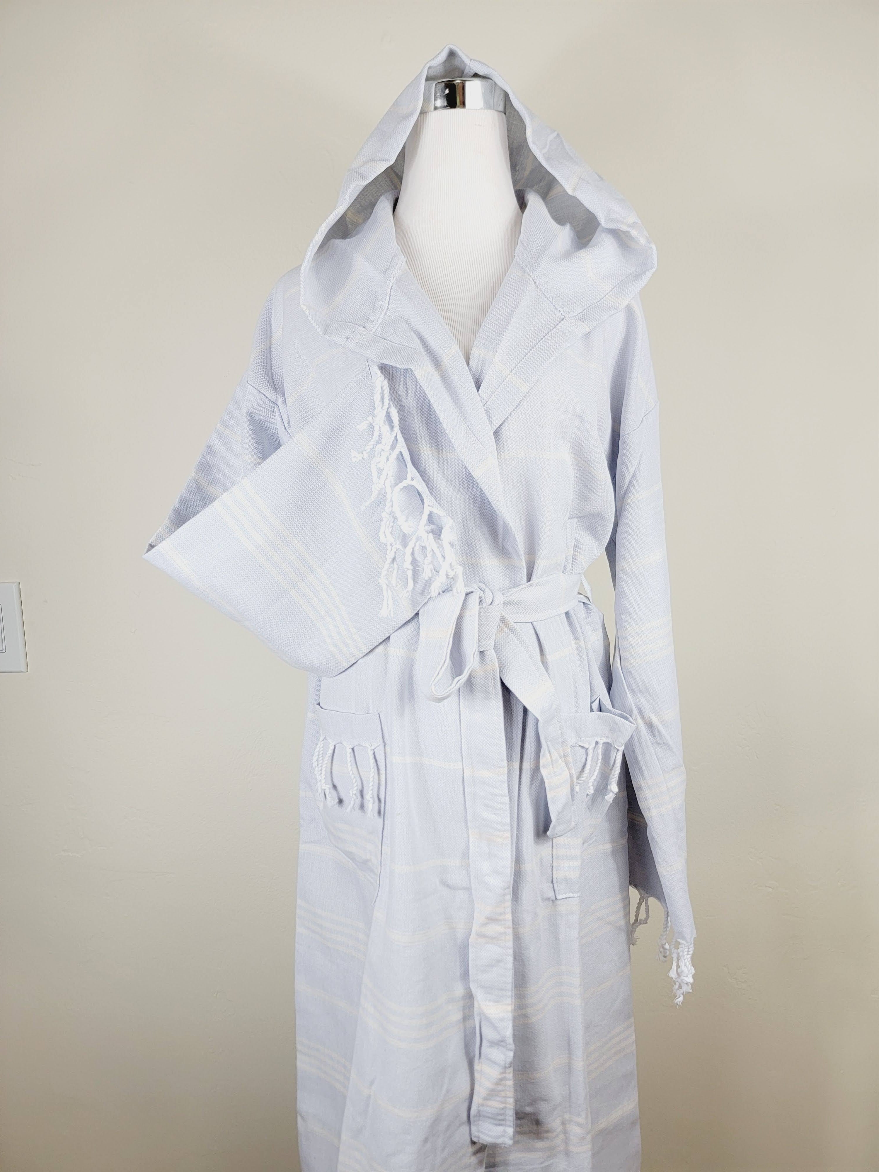 Light gray hooded robe on a mannequin against a beige background