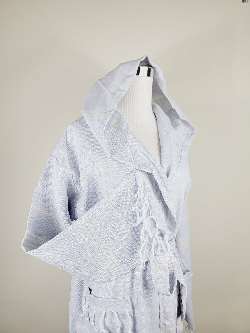 Light blue hooded garment on a mannequin against a beige background