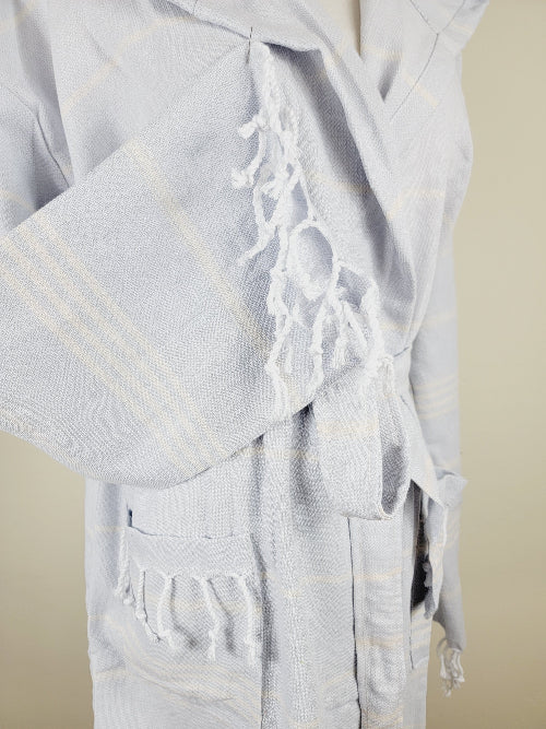 Light blue prayer shawl with tassels on a beige background