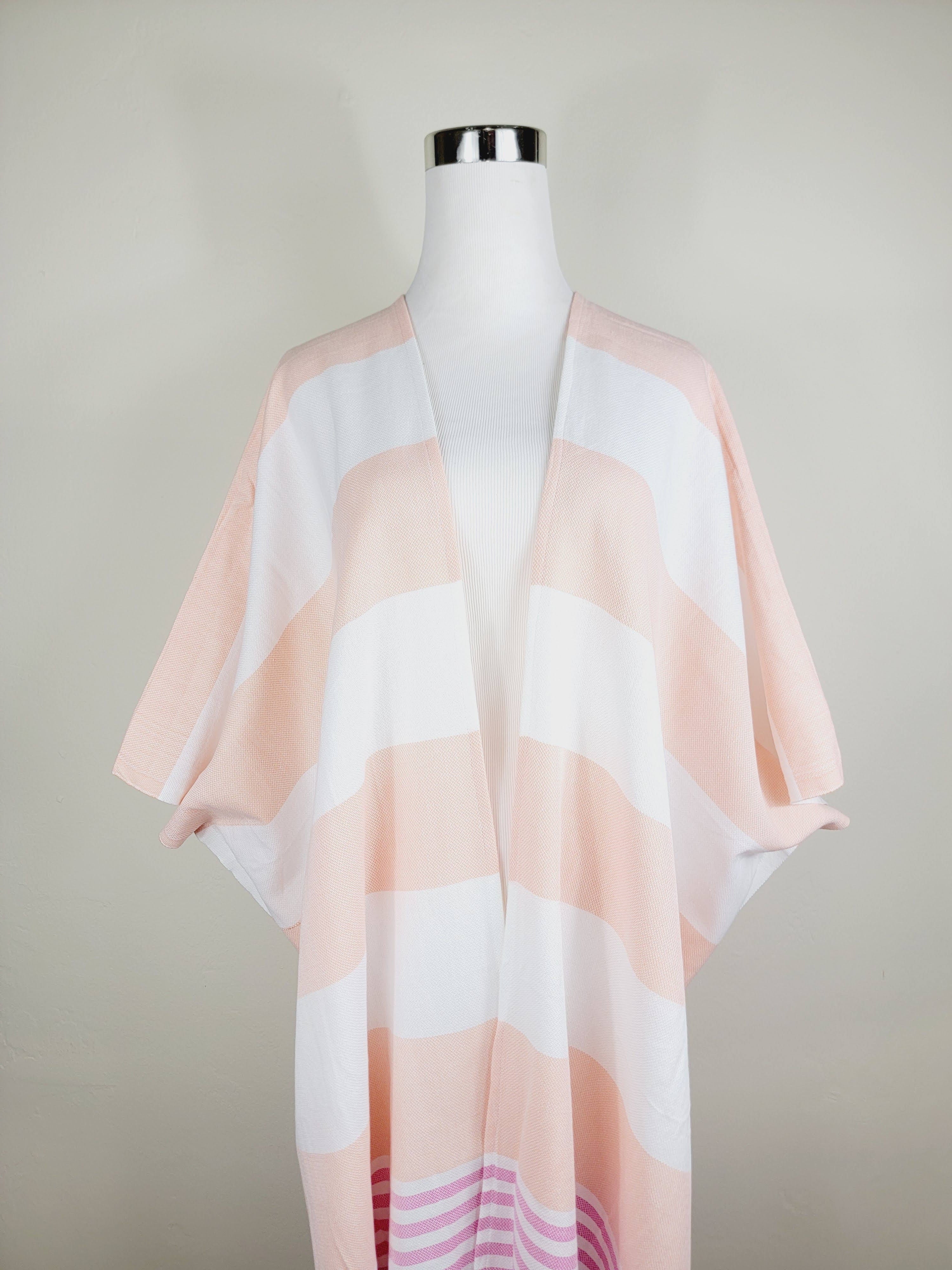 Mannequin wearing a light pink and white striped kimono against a plain background
