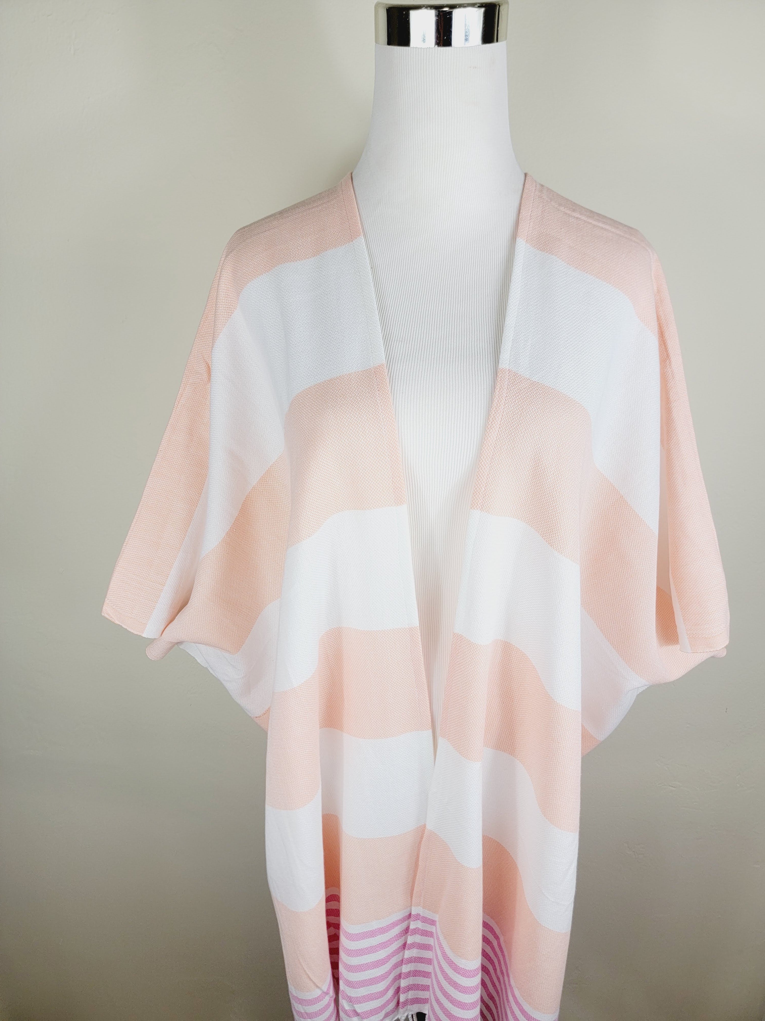 Mannequin wearing a light pink and white striped kimono-style garment against a plain background