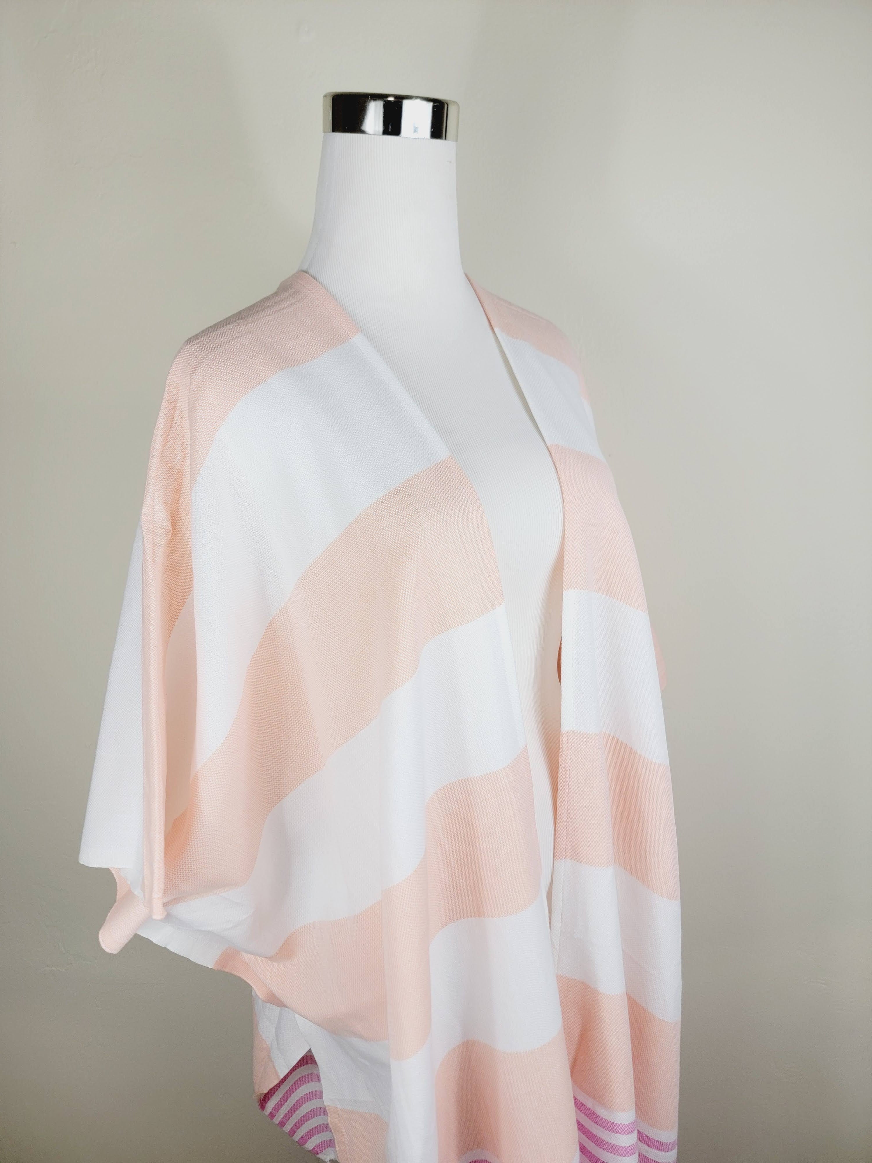 Mannequin wearing a light pink and white striped scarf against a plain background