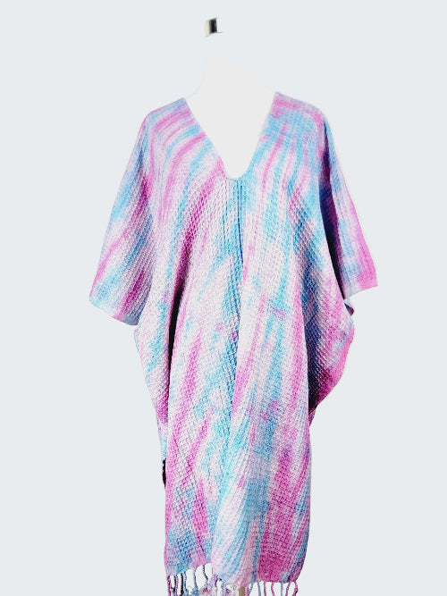 Colorful poncho with pink and blue patterns on a white background