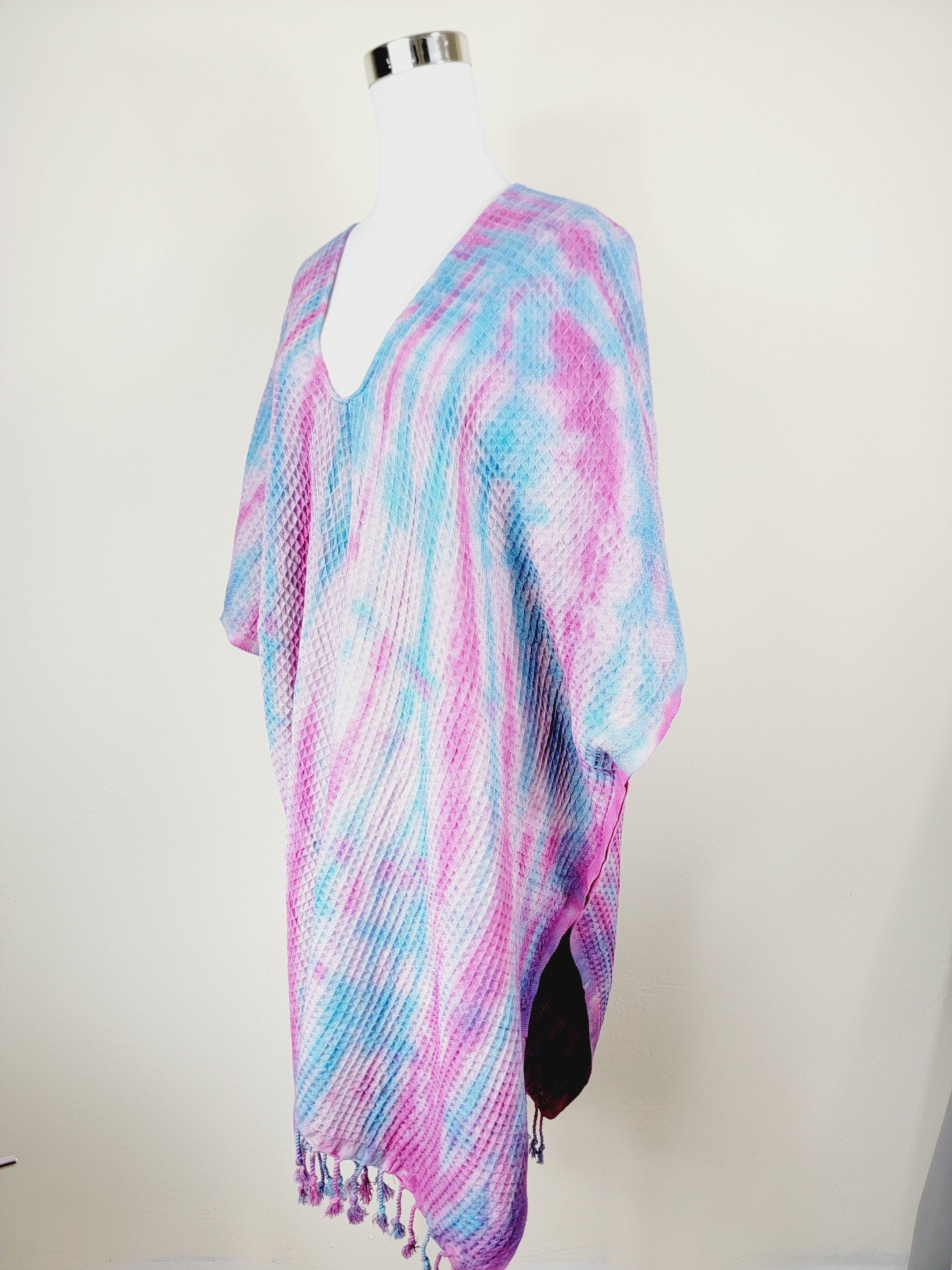 Multicolored knitted shawl on a mannequin against a white background