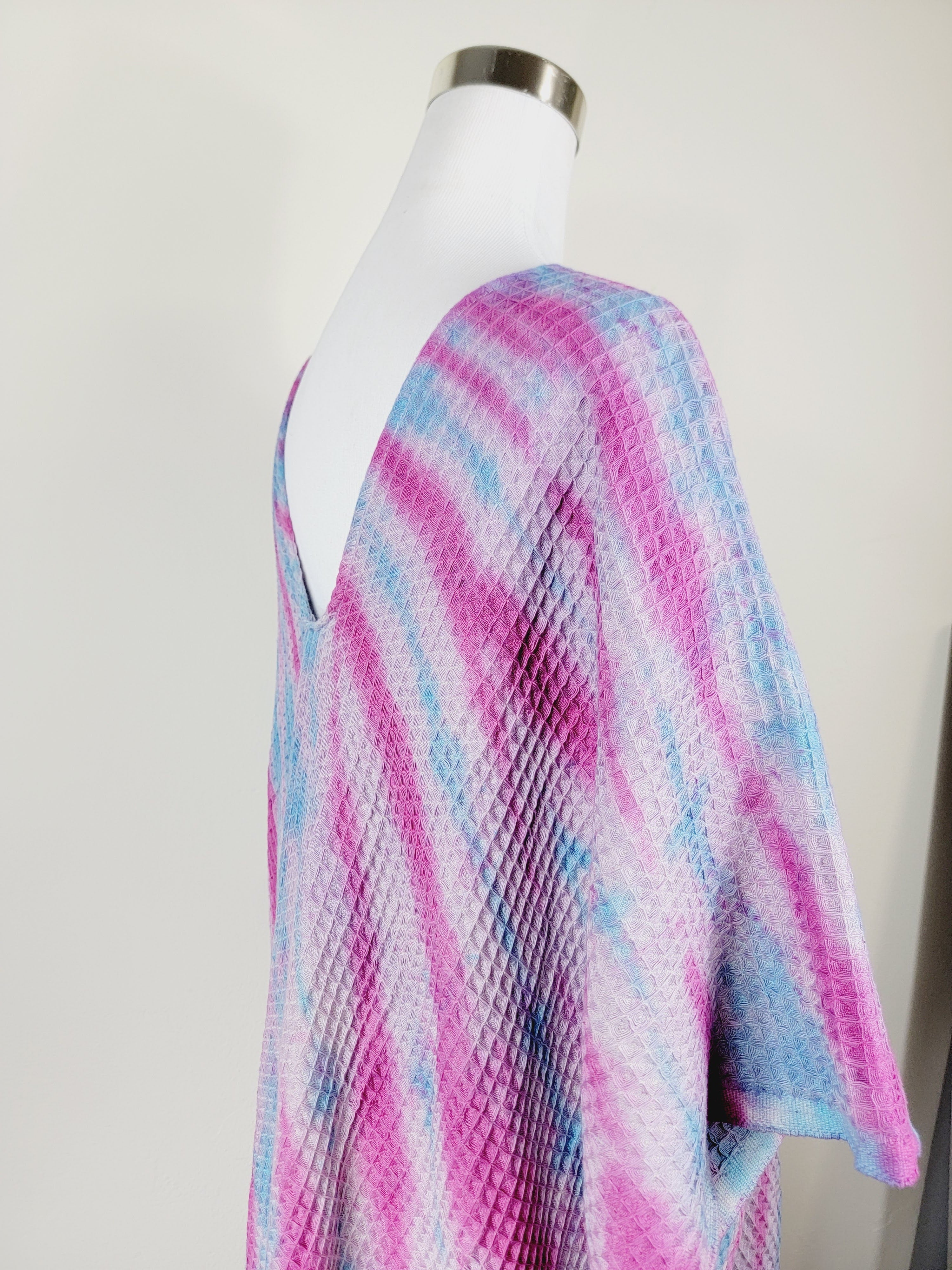 Mannequin wearing a colorful tie-dye shirt against a white background