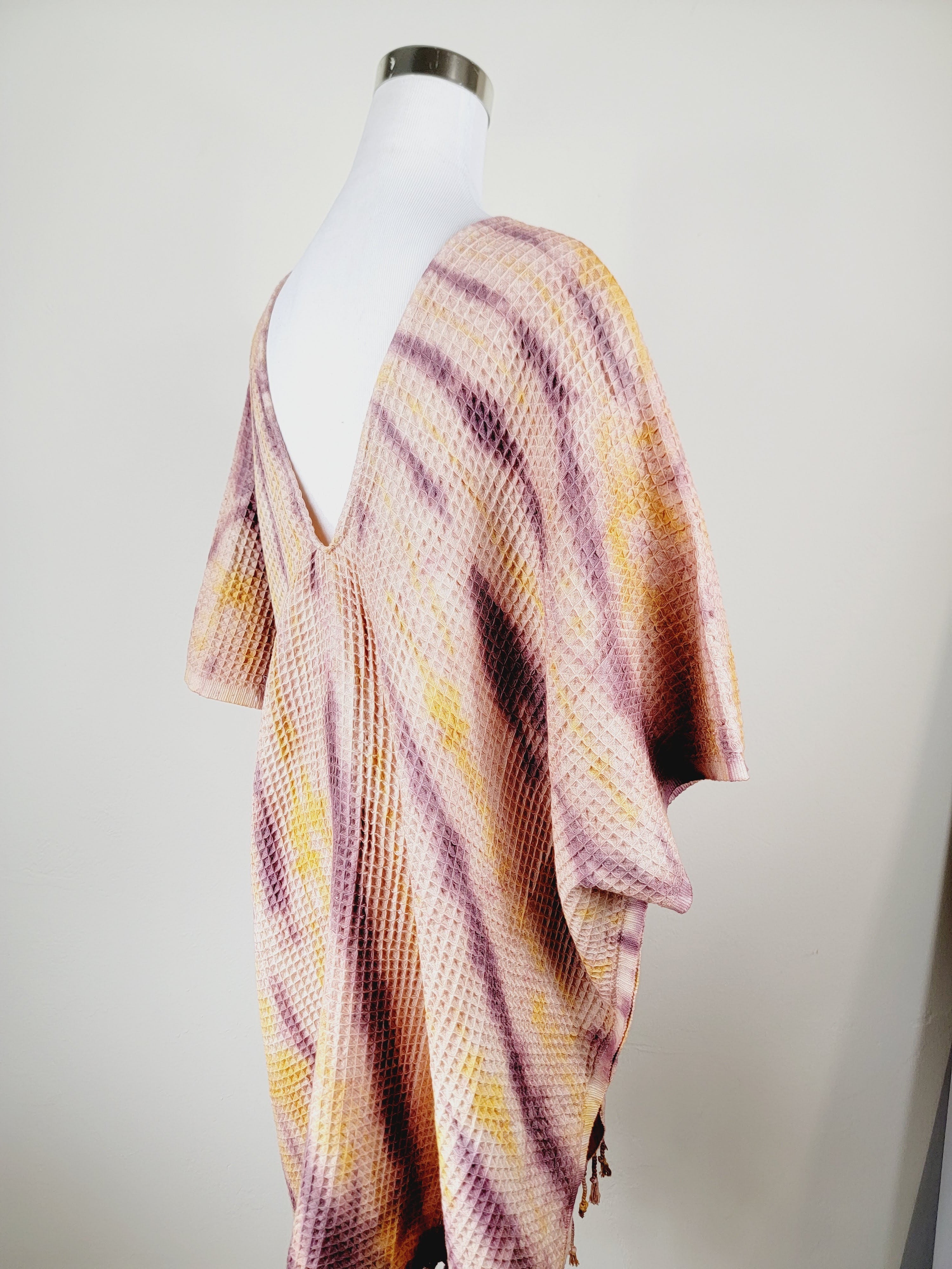 Mannequin wearing a colorful striped dress against a white background