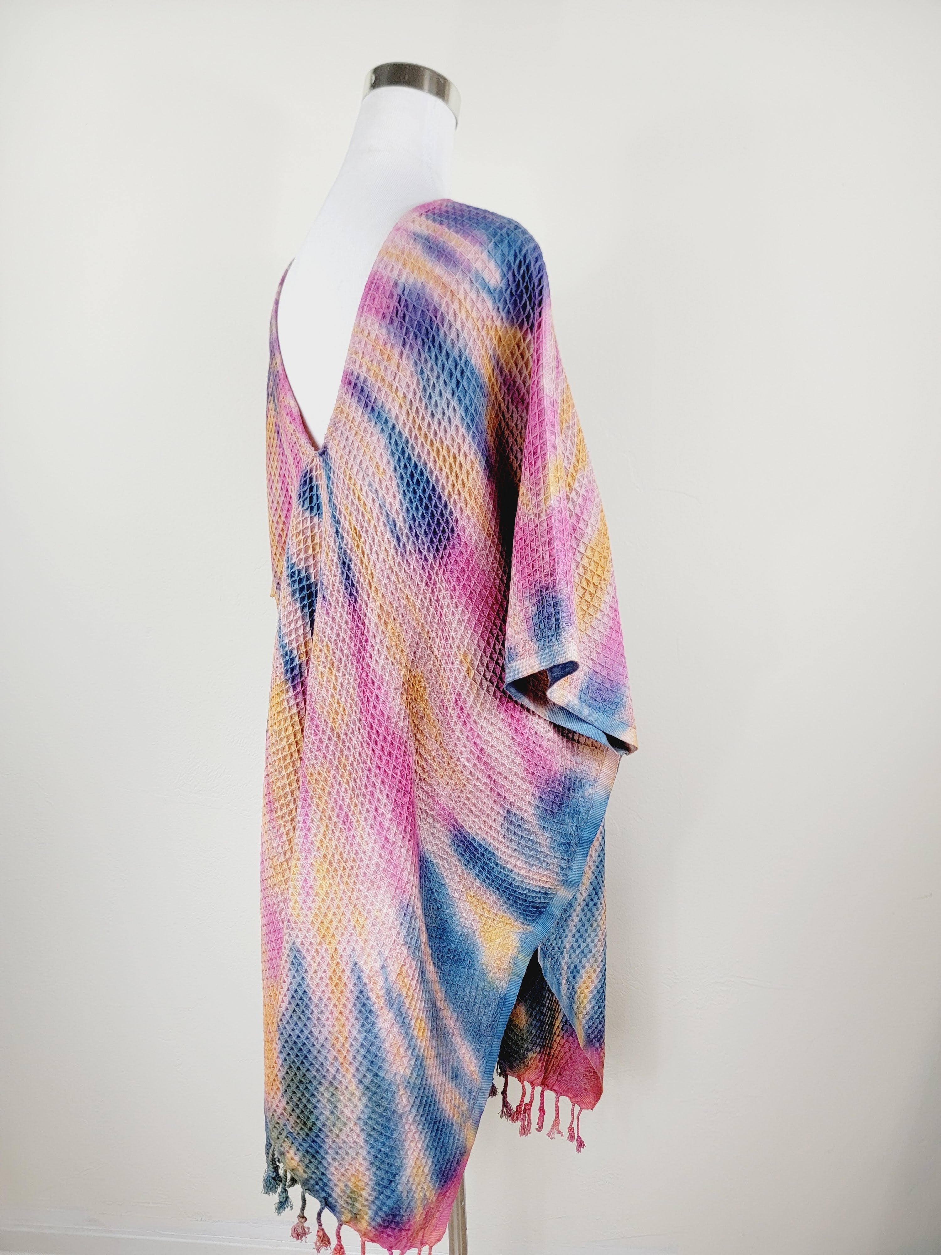 Colorful striped shawl on a mannequin against a white background