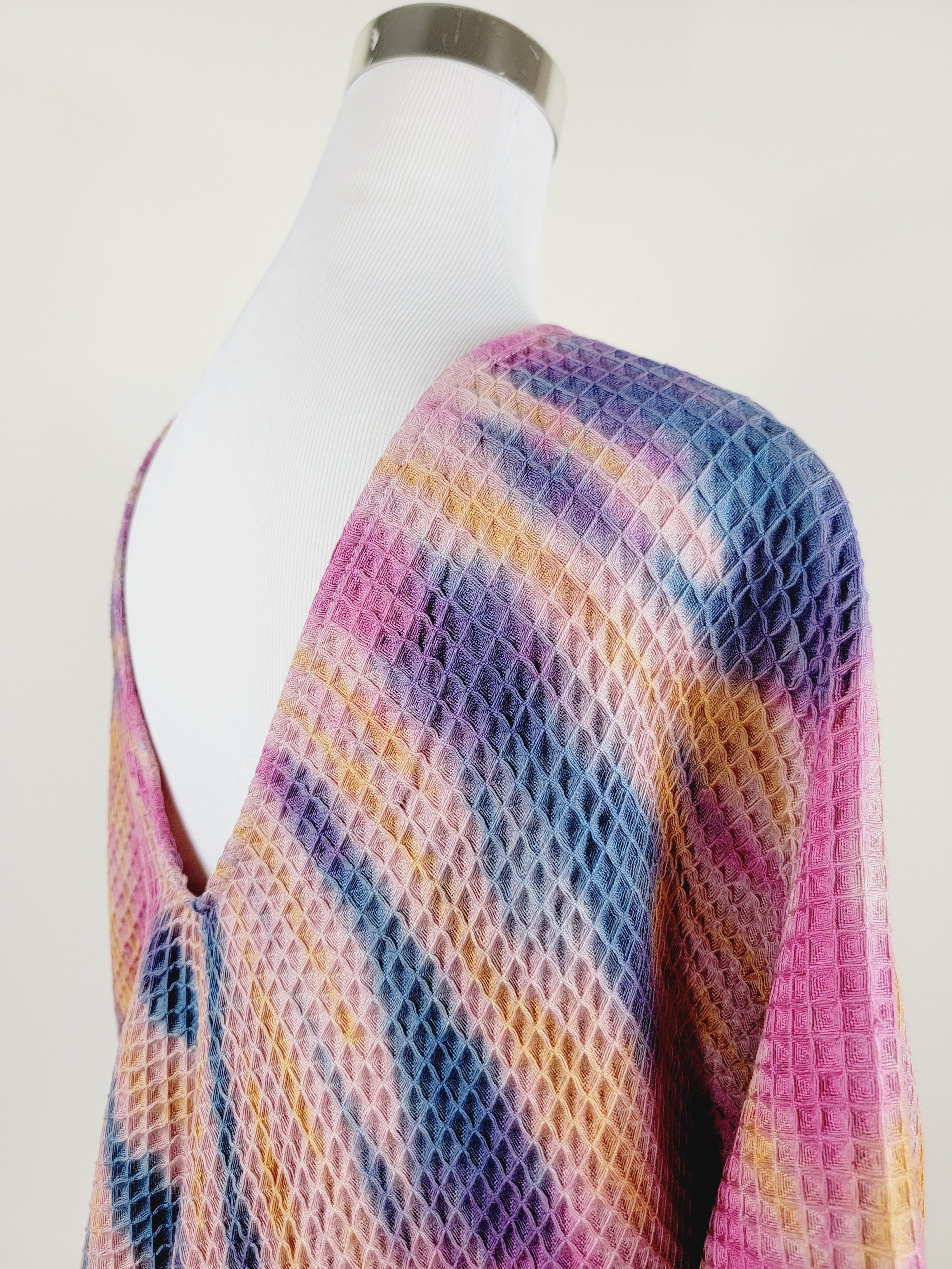 Mannequin wearing a colorful, patterned shawl on a white background
