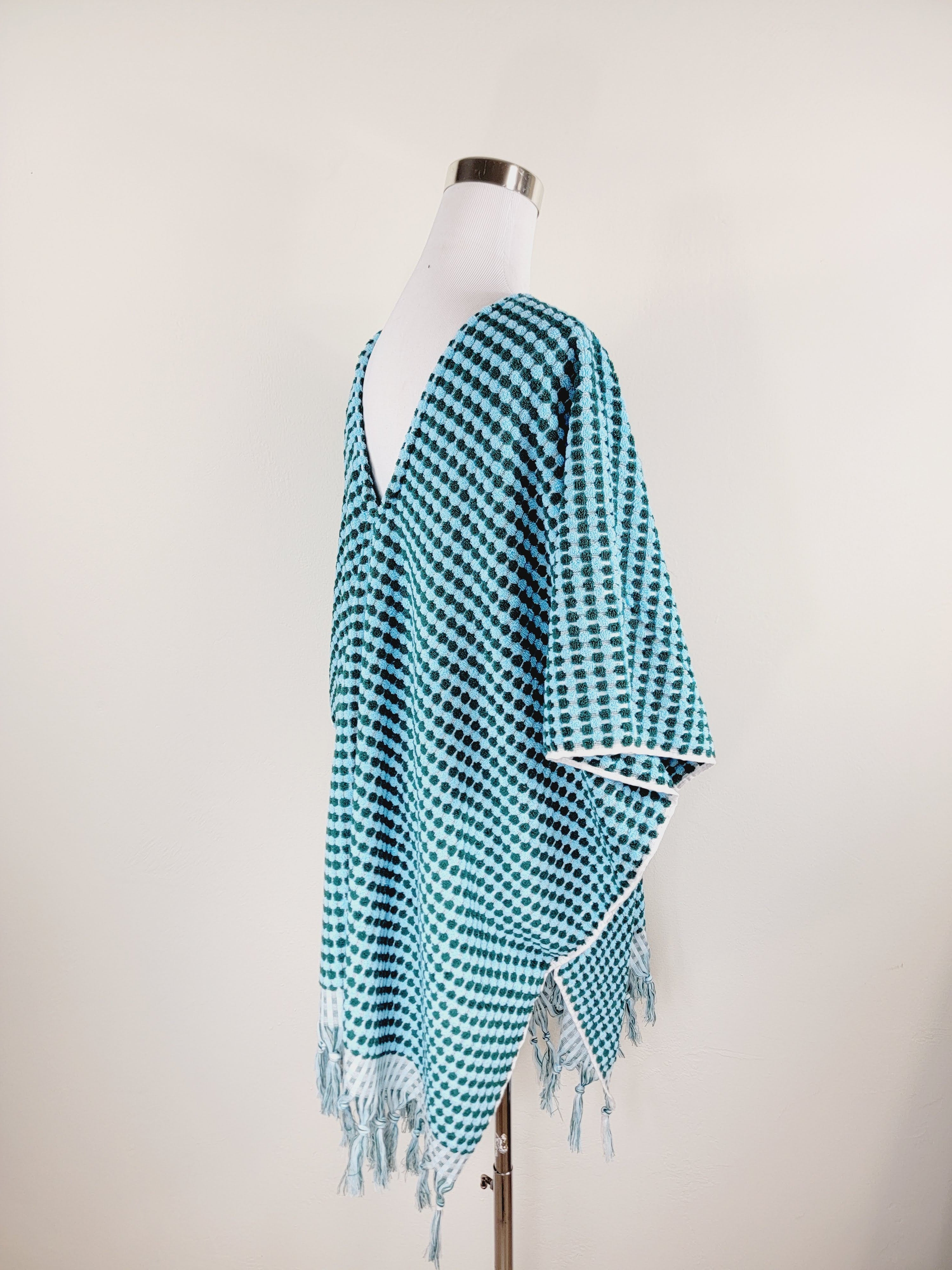 Teal and white checkered scarf on a mannequin against a plain background
