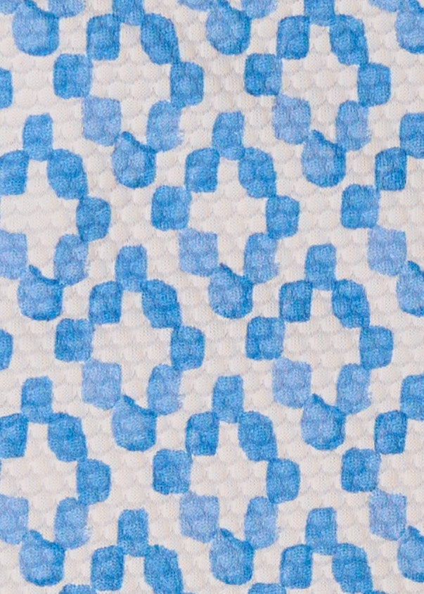 Patterned fabric with blue geometric shapes on a beige background