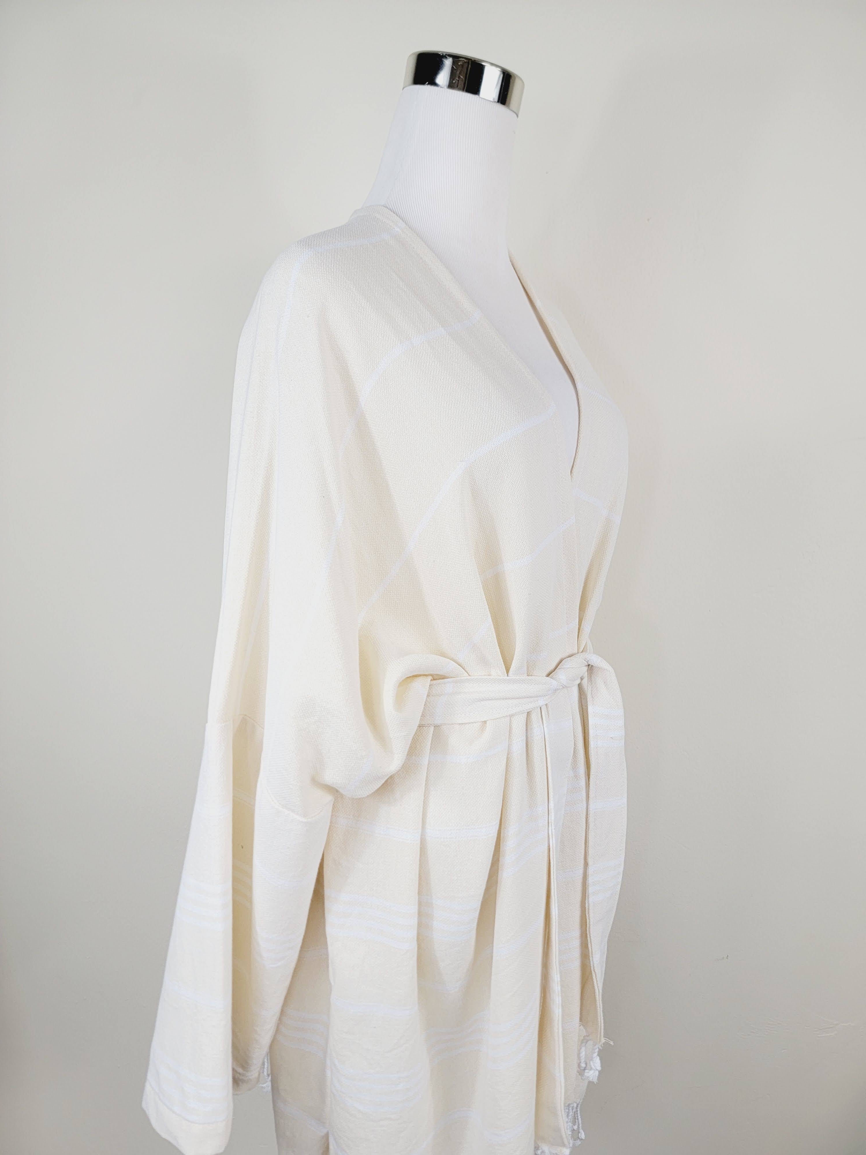 White robe on a mannequin against a plain background