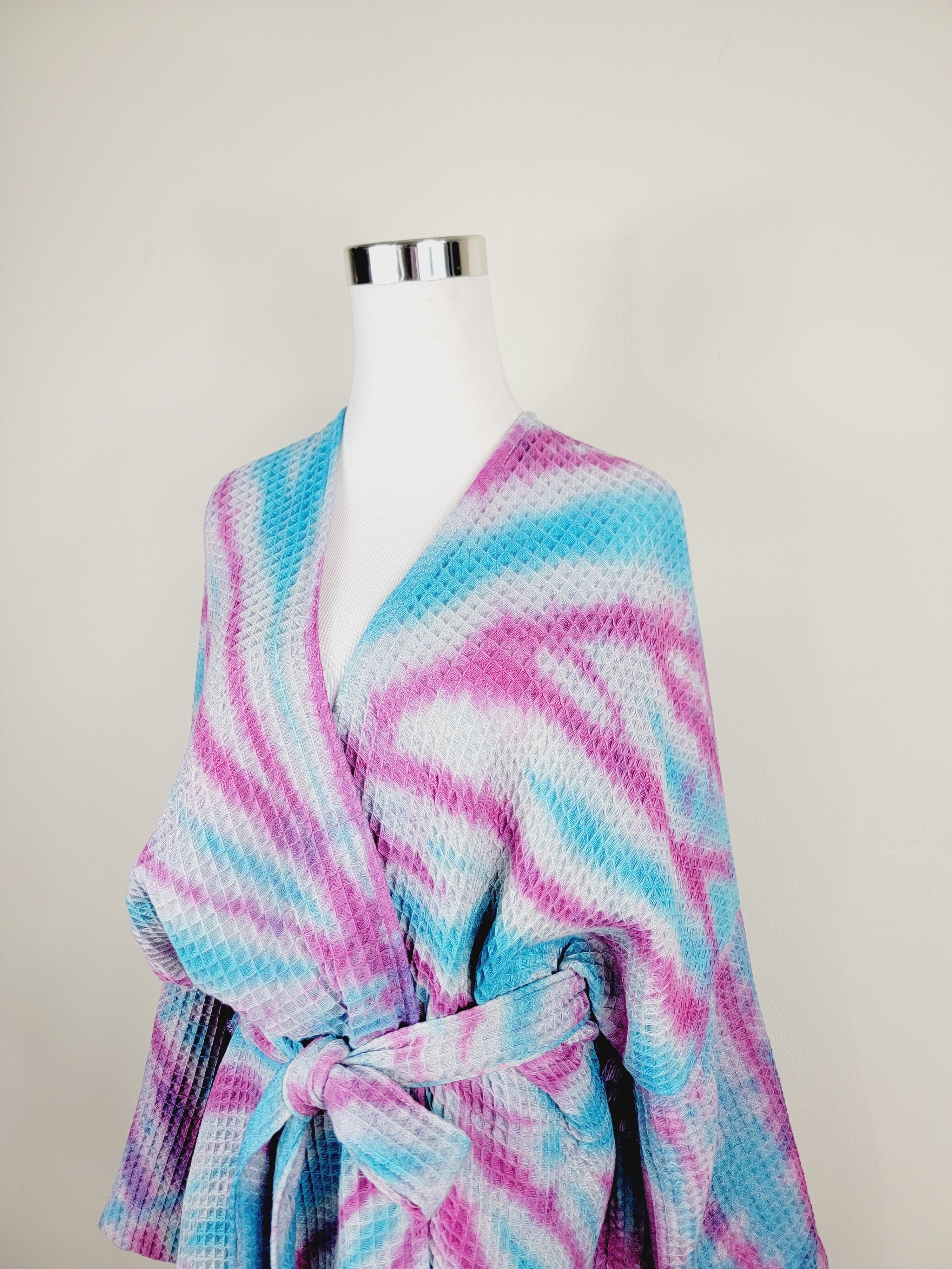 Mannequin wearing a colorful tie-dye robe against a plain background