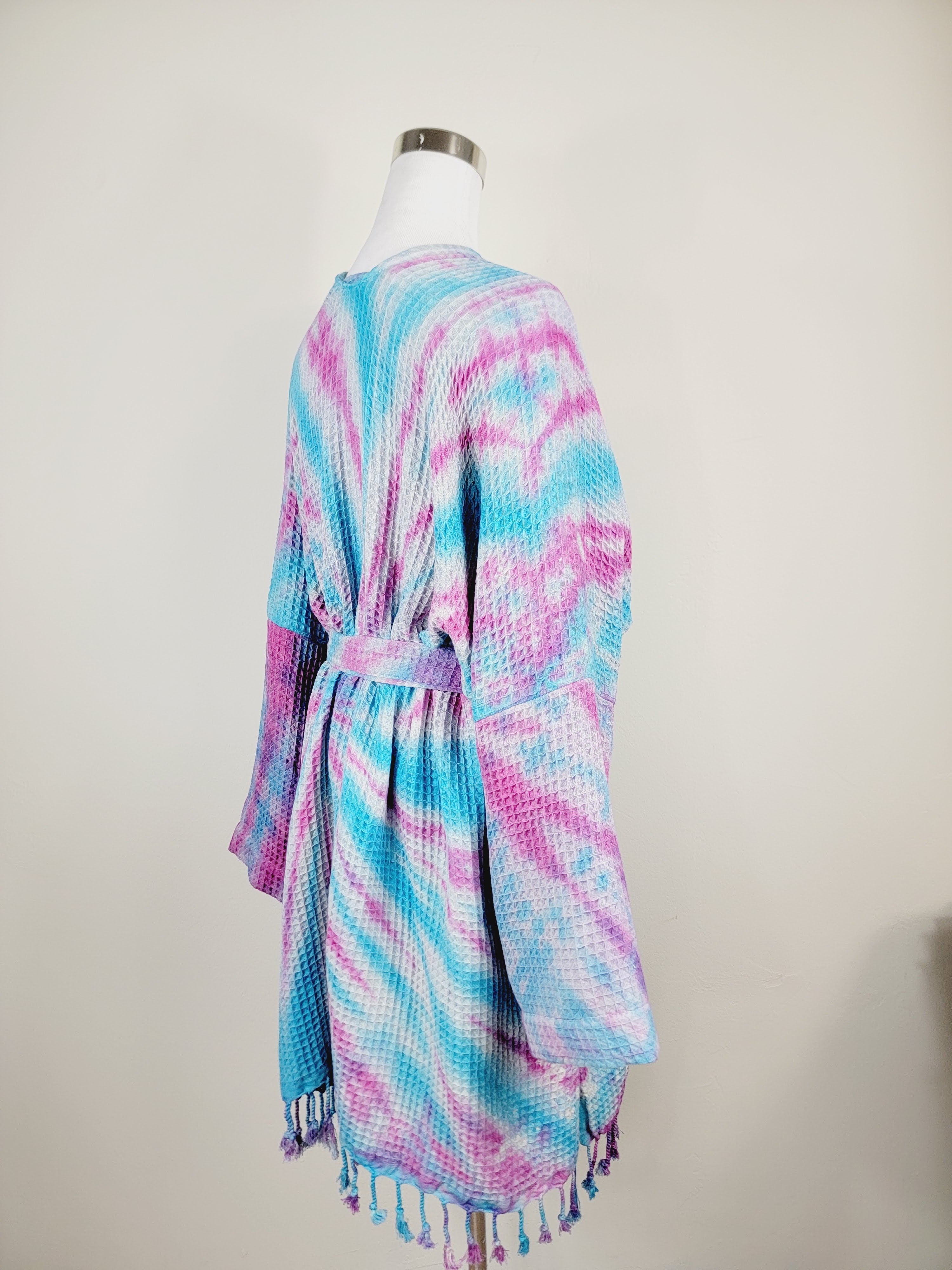 Tie-dye kimono with fringes on a mannequin against a white background