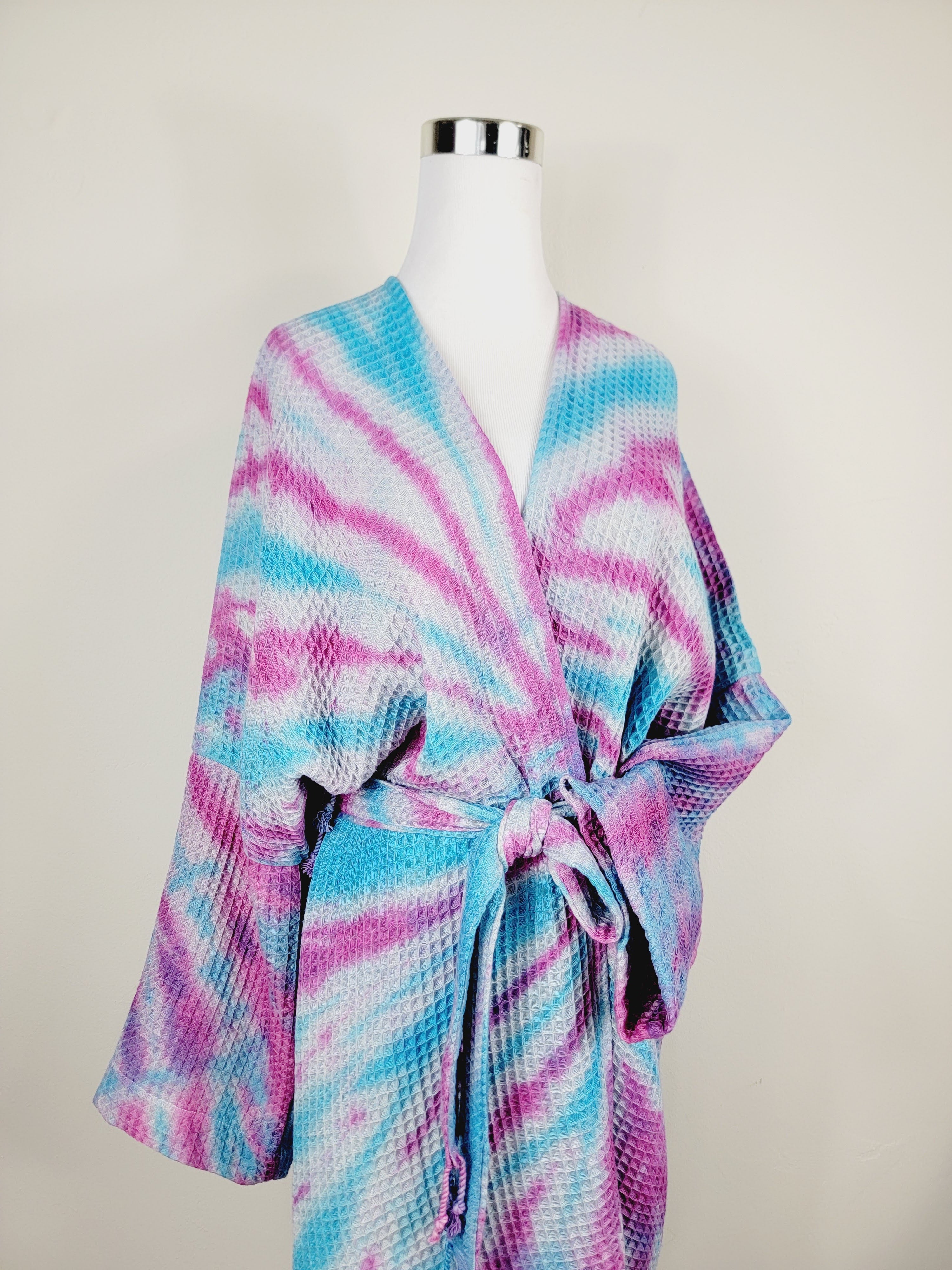 Tie-dye robe on a mannequin against a plain background
