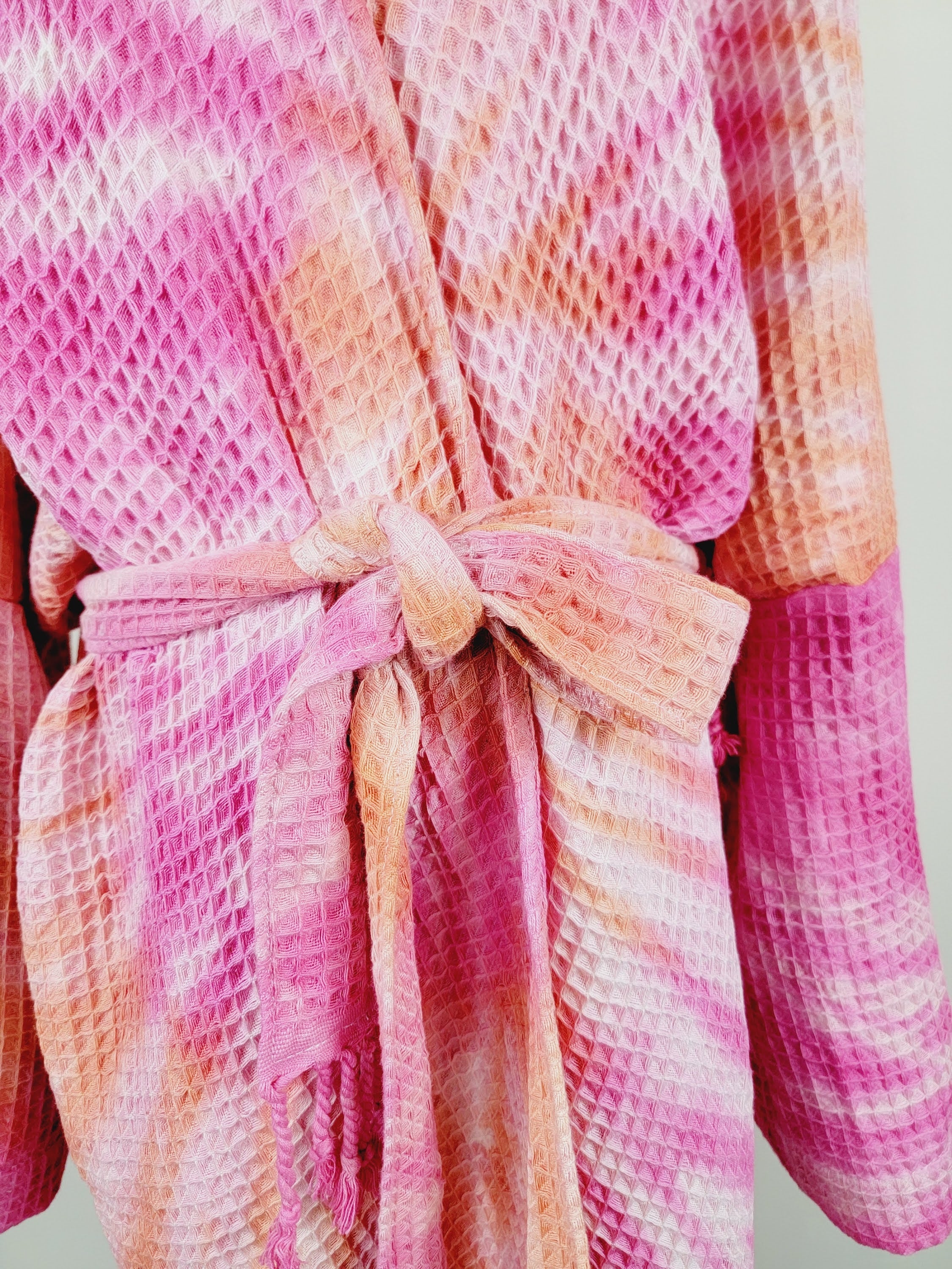 Pink and orange textured robe on a light gray background