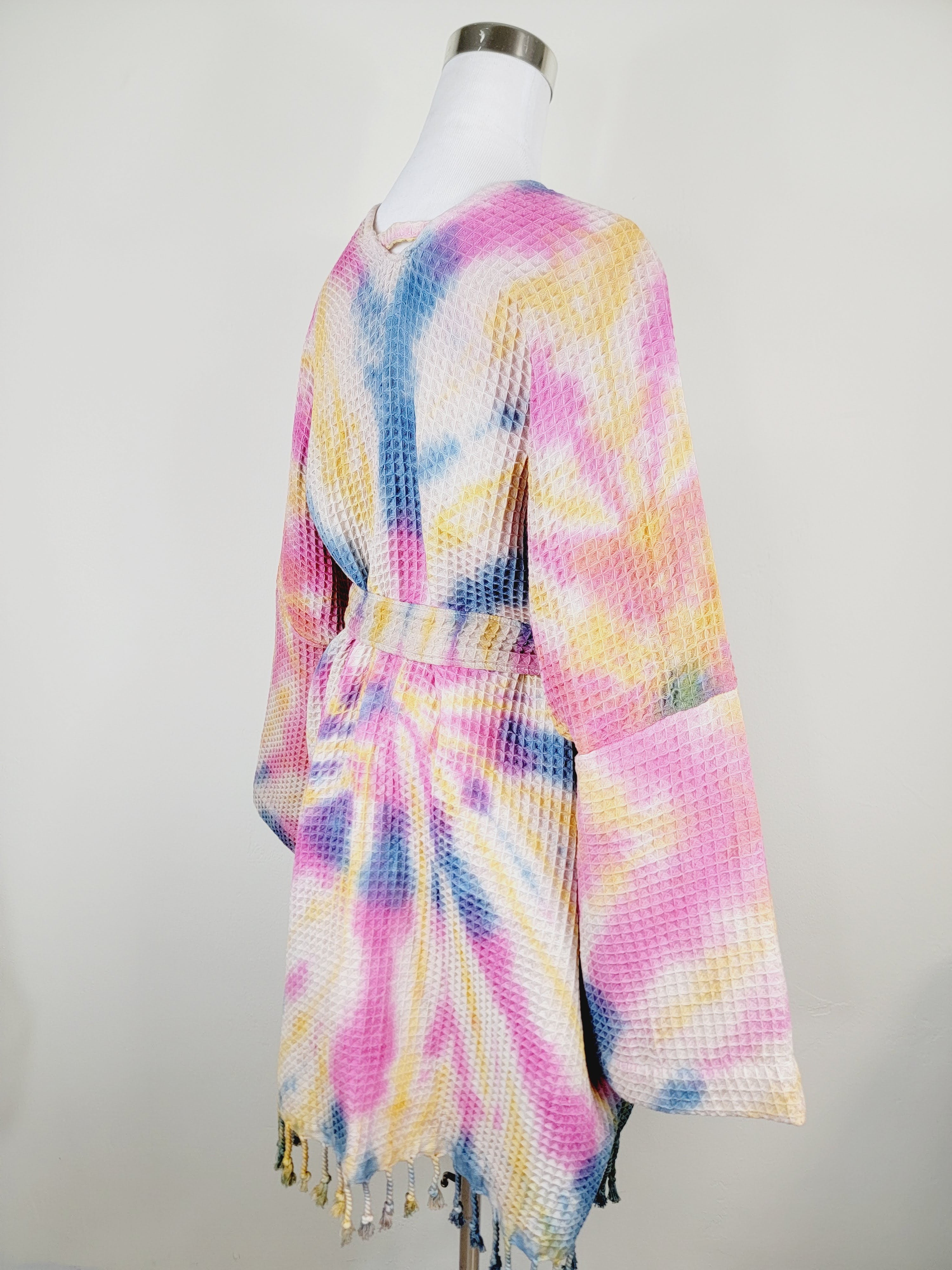 Colorful tie-dye cardigan on a mannequin against a white background