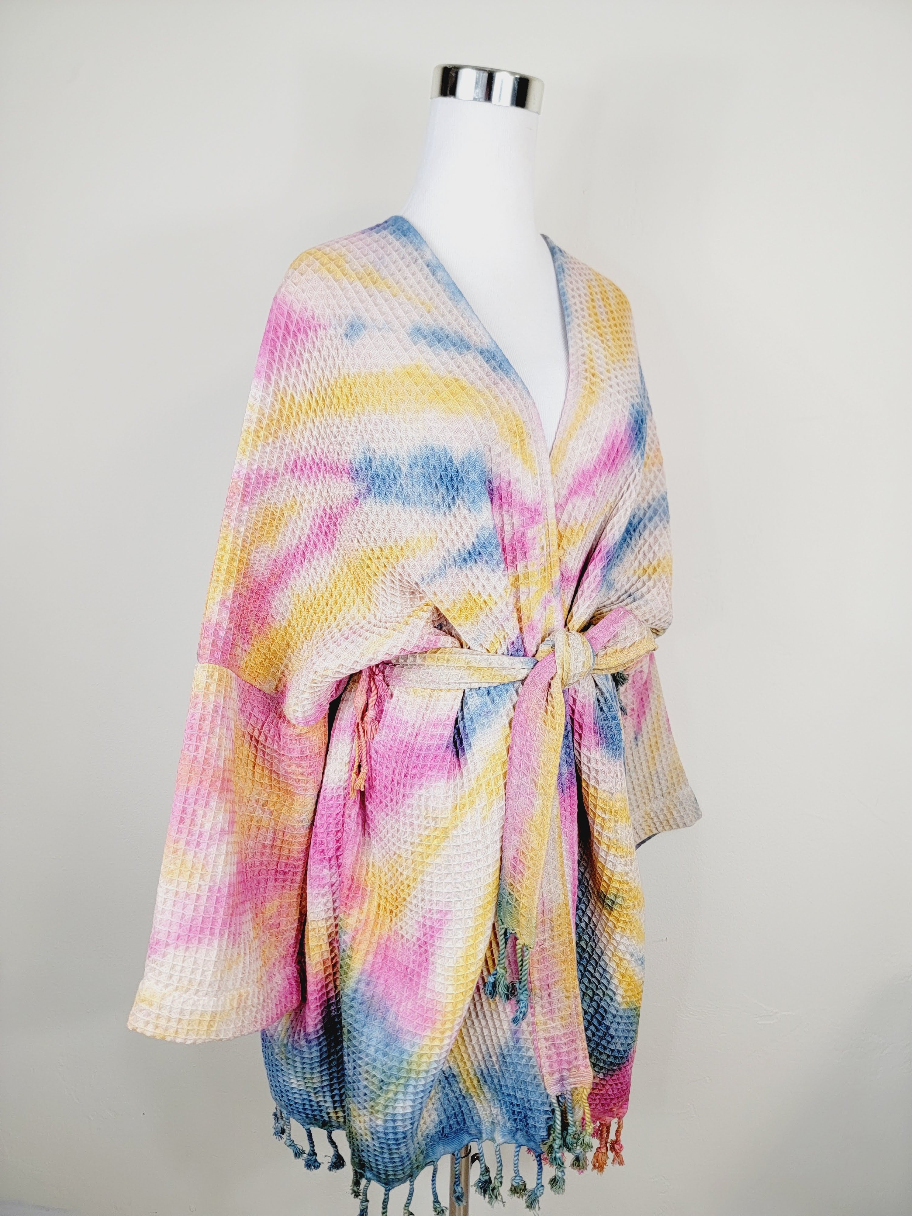 Colorful tie-dye kimono-style garment on a mannequin against a plain background