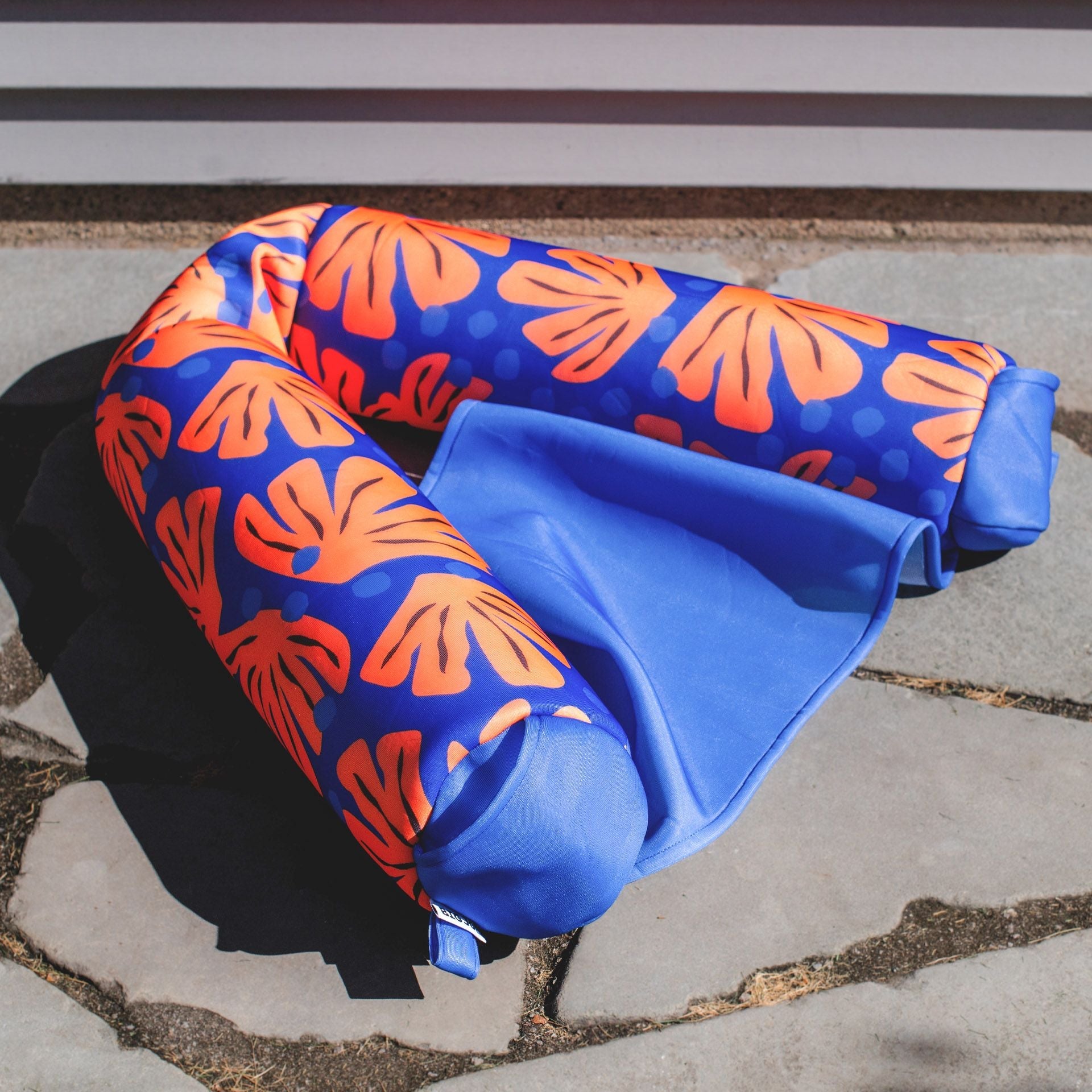Blue and orange inflatable pillow on a concrete surface