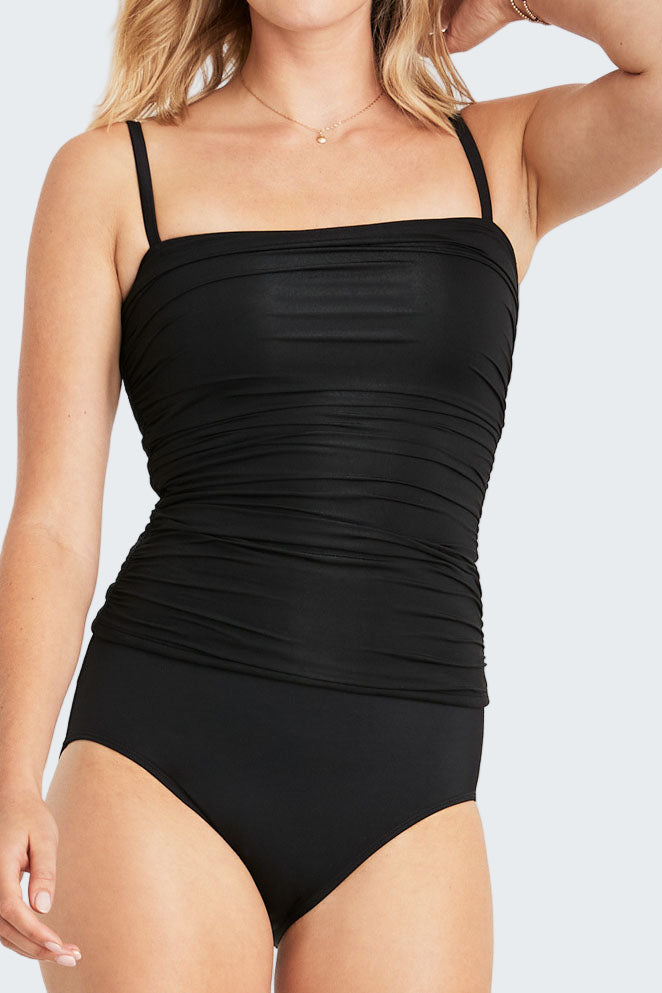 Black swimsuit worn by a model on a white background