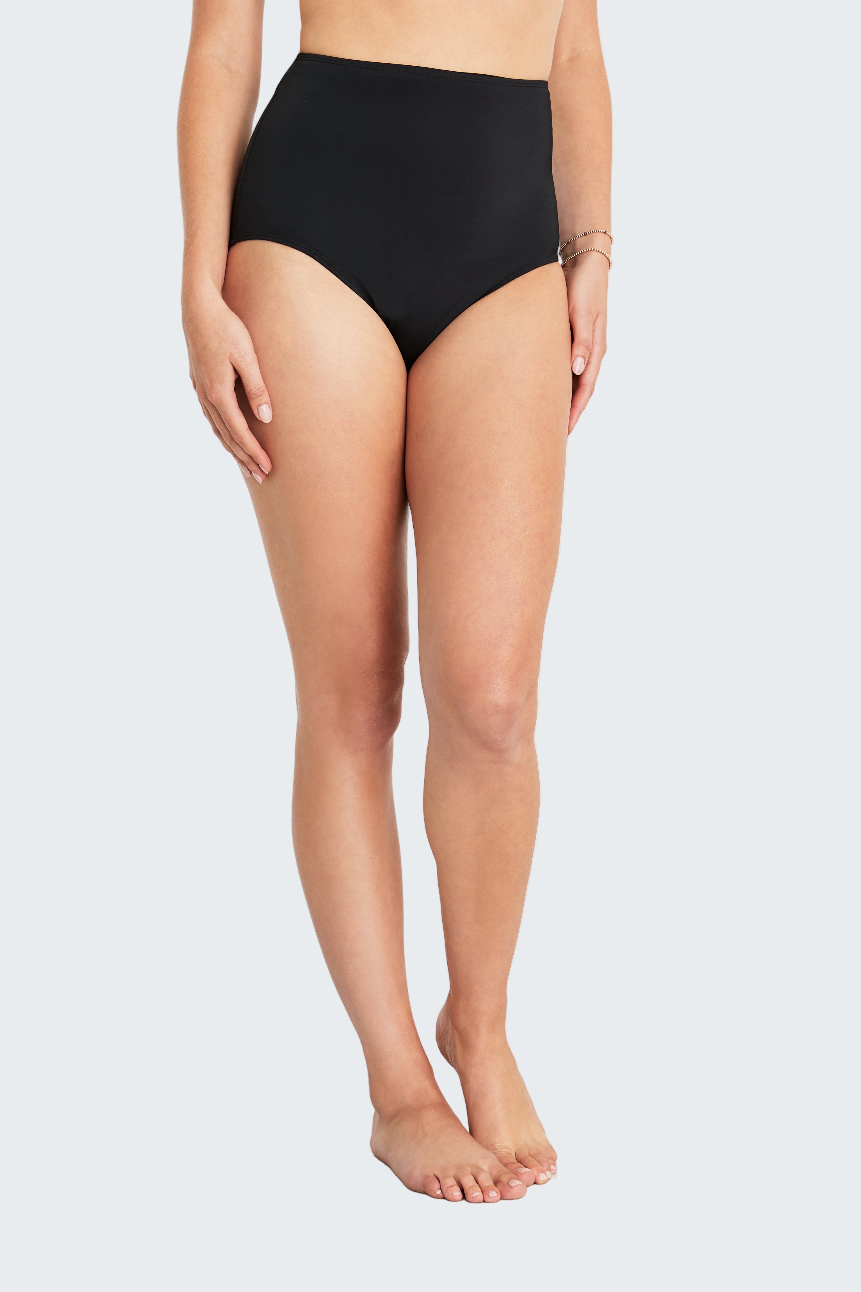 Person wearing black high-waisted bikini bottoms on a white background