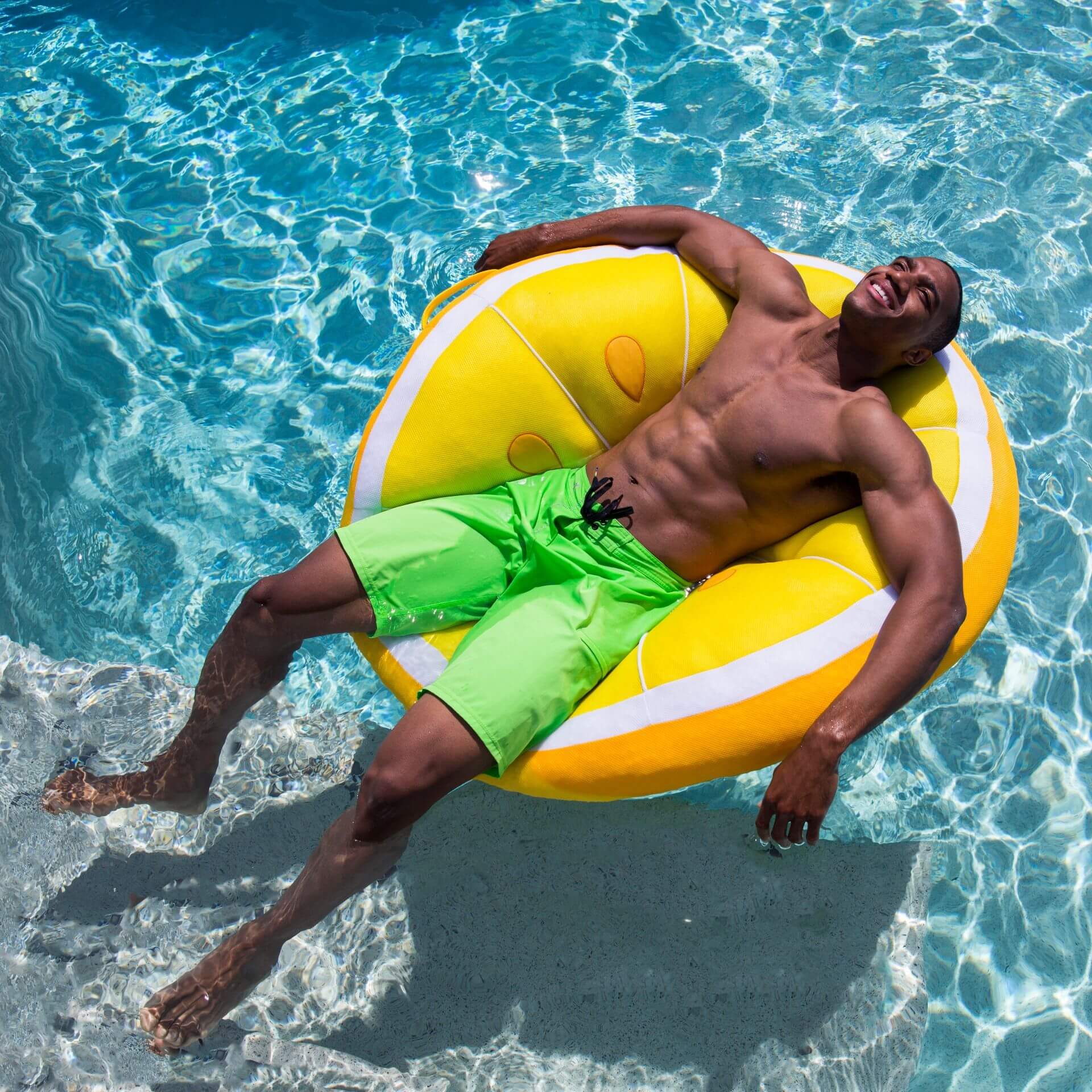 Man lying on a yellow inflatable ring in a pool
