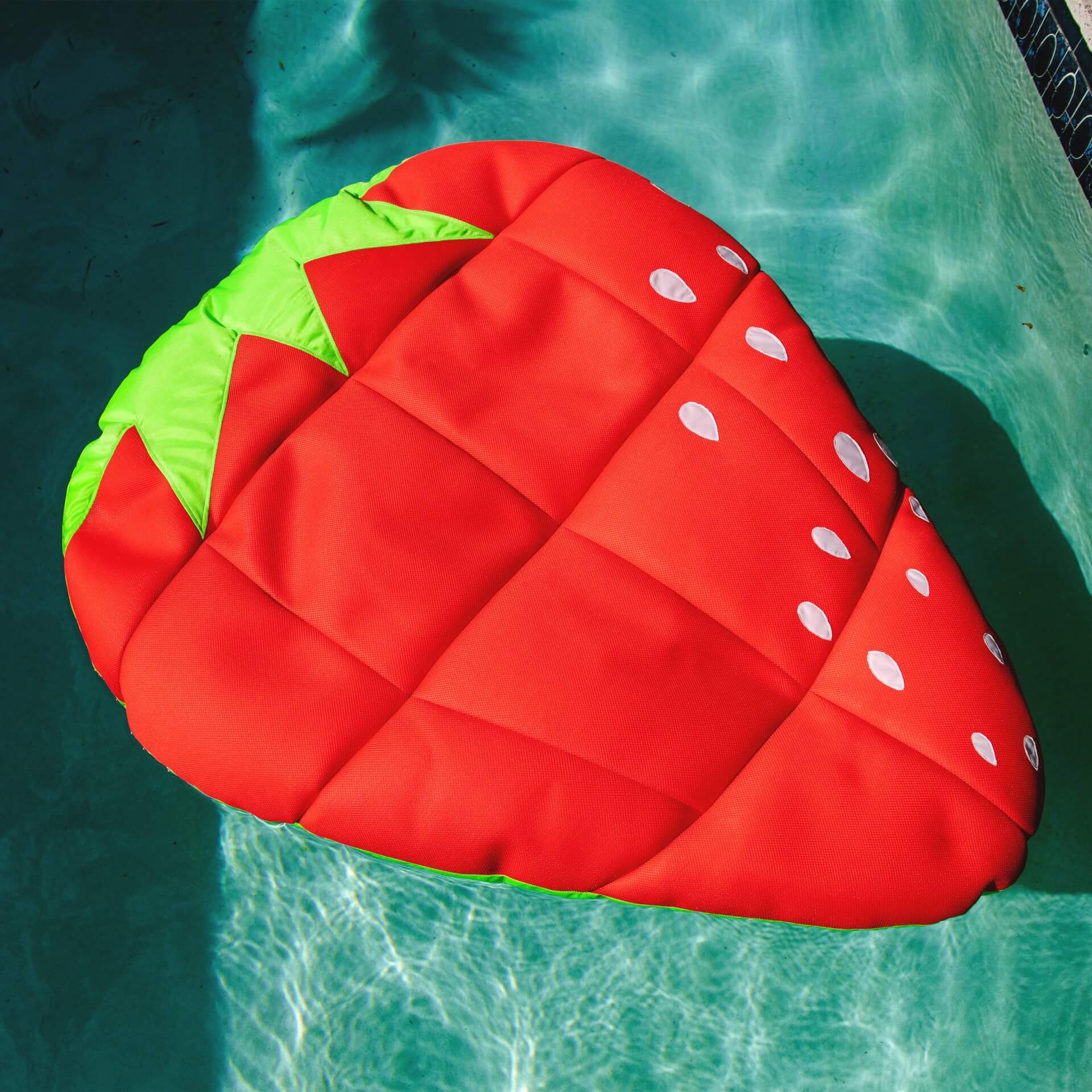 Inflatable strawberry pool floatie on a pool