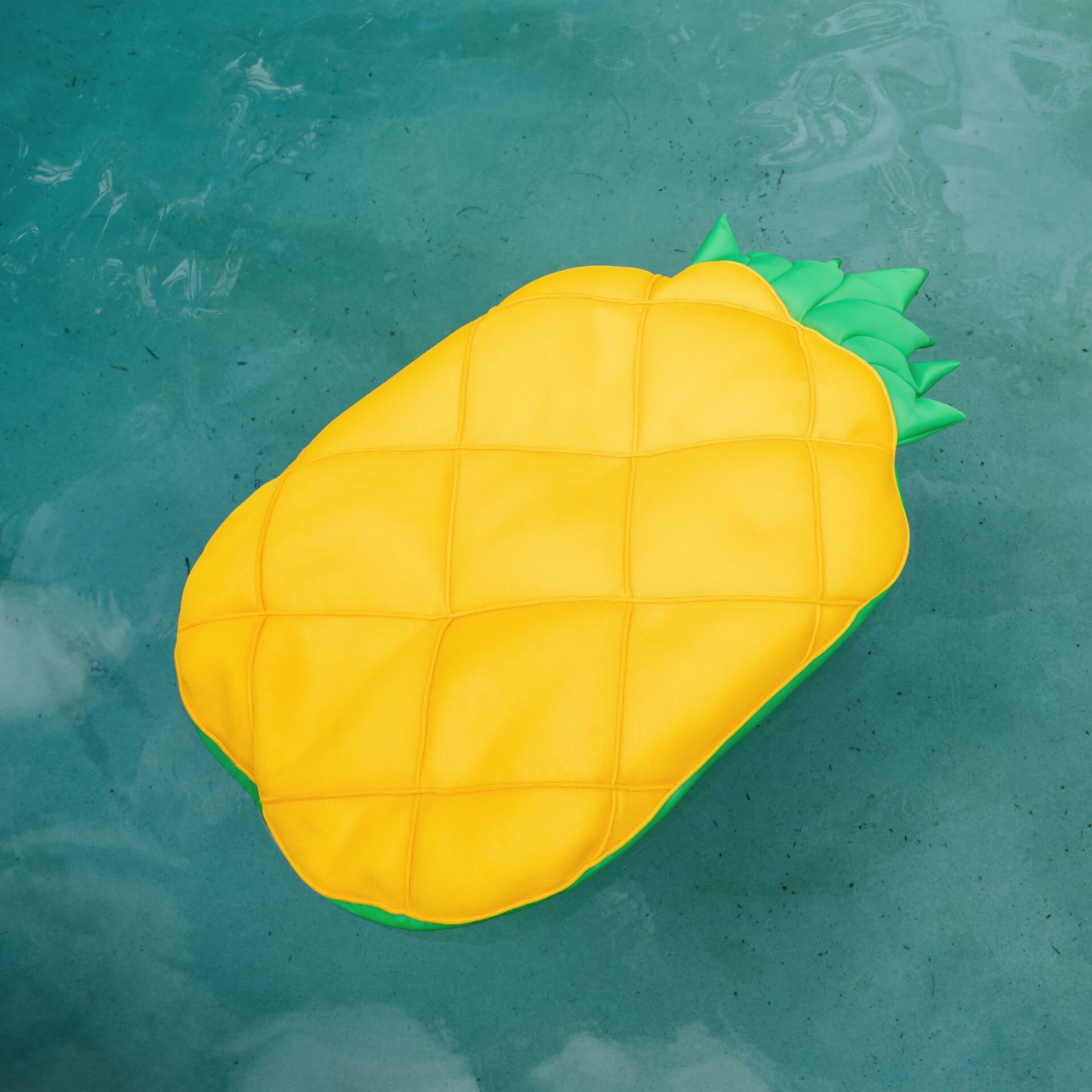 Yellow pineapple-shaped pool float on a blue pool surface