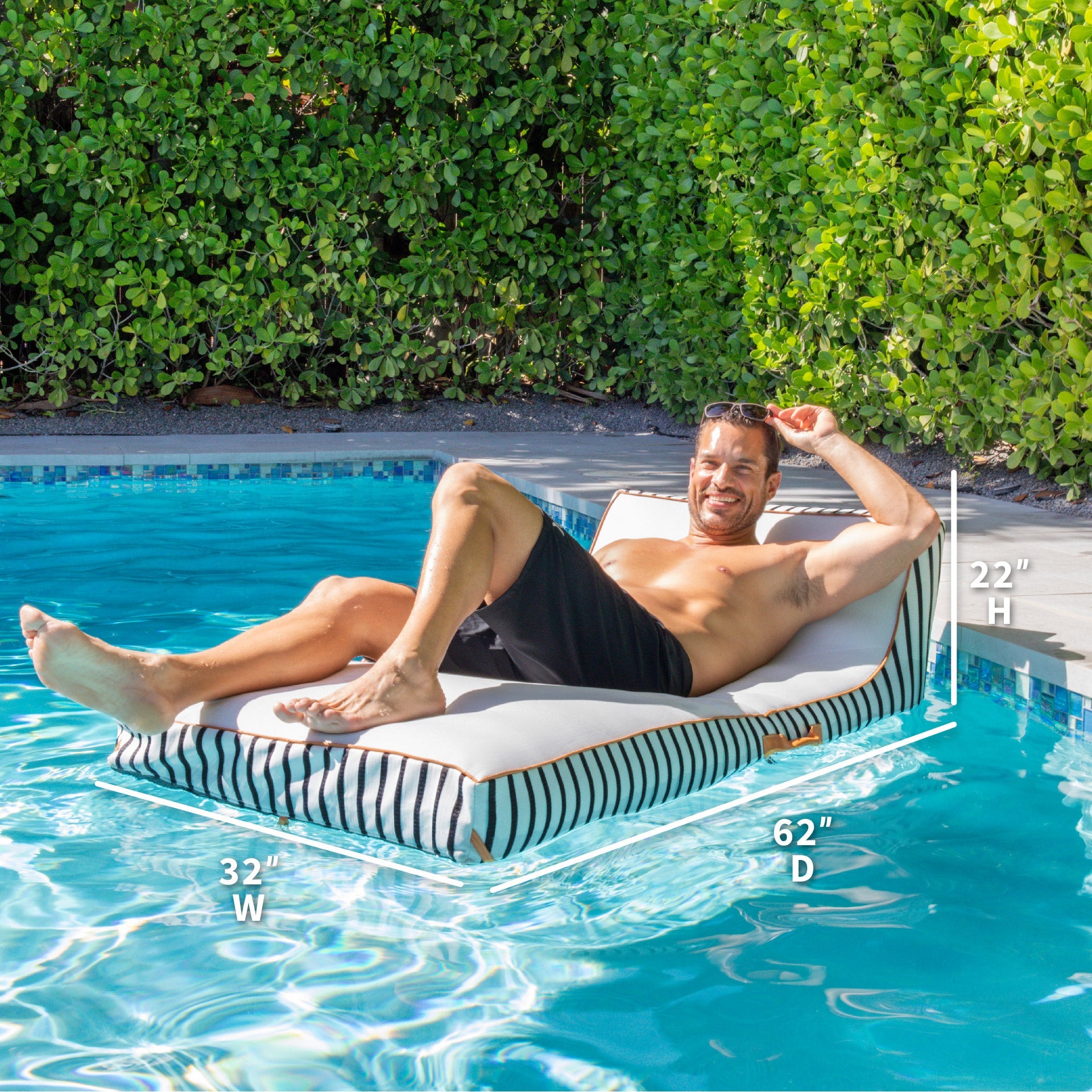 Man lounging on a striped pool float in a pool with dimensions displayed