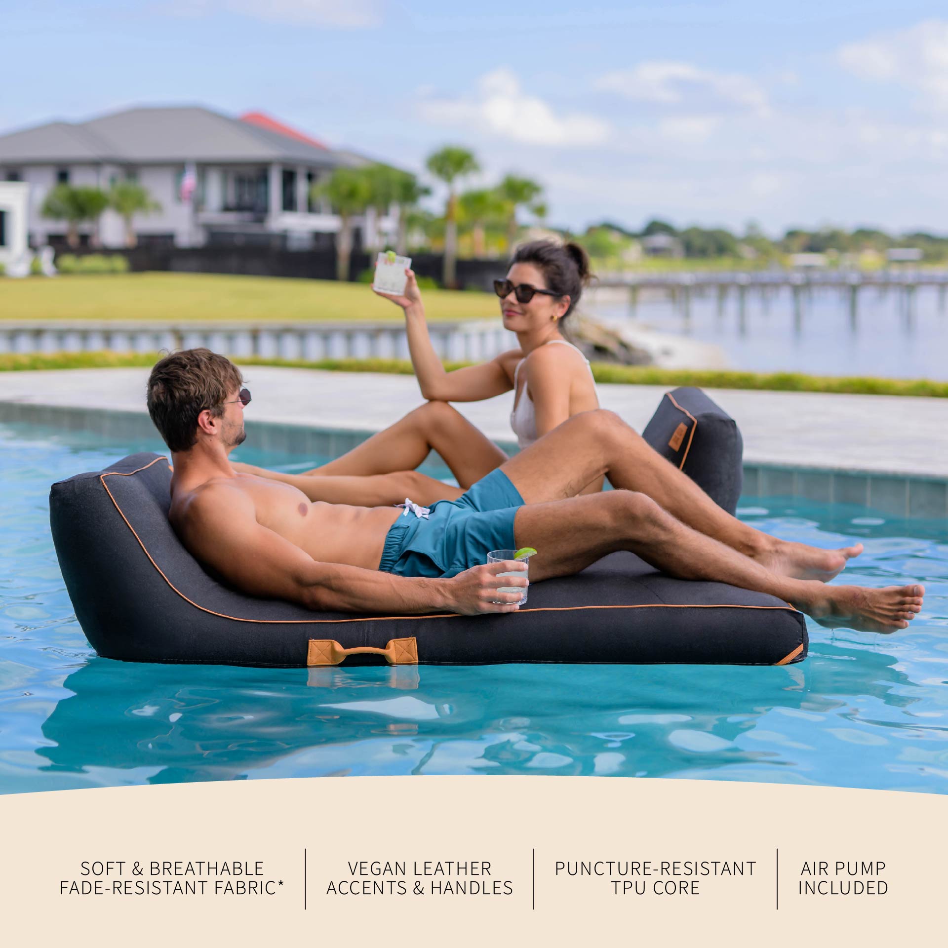 Two people relaxing on a floating inflatable lounger by a pool.