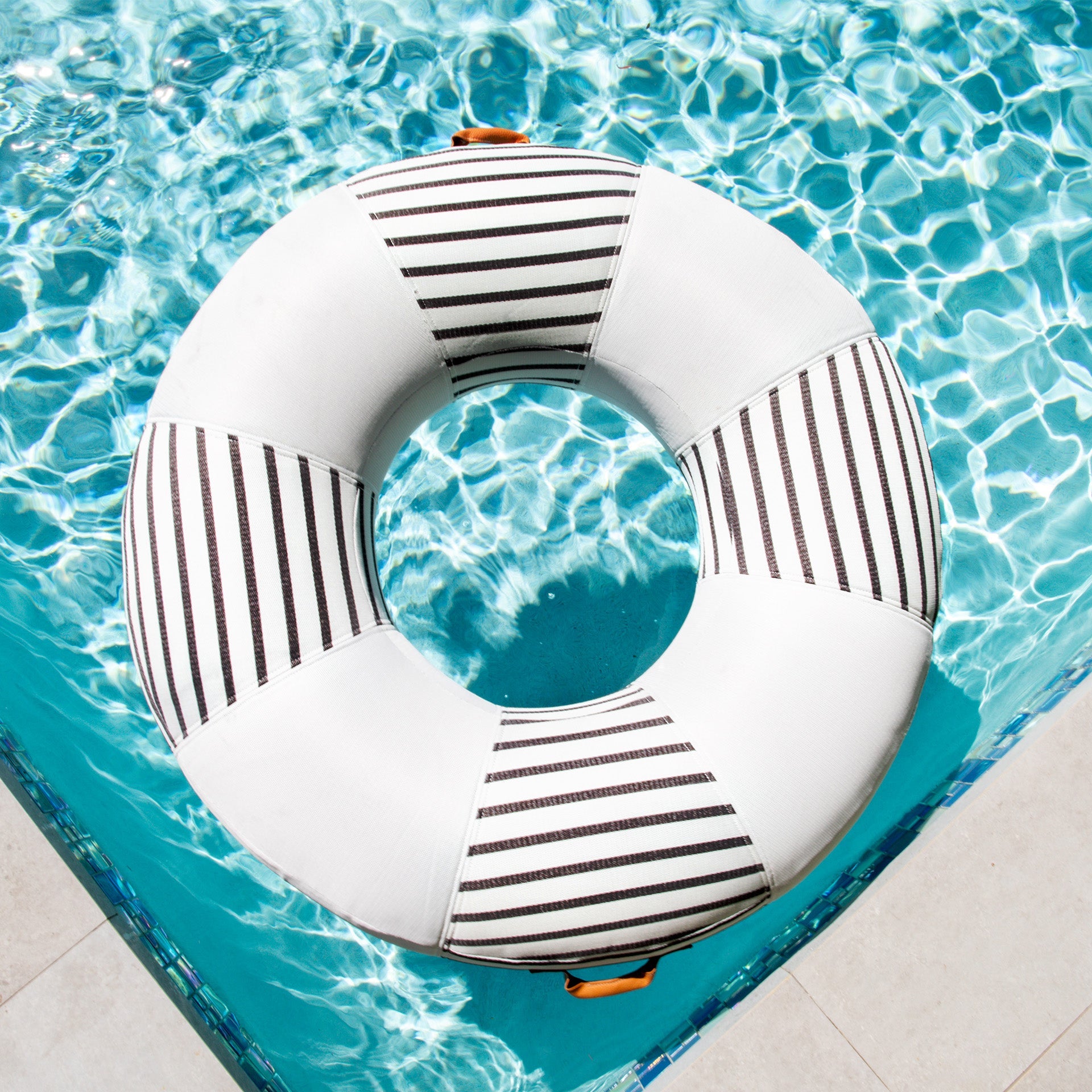 White inflatable ring with black stripes in a pool