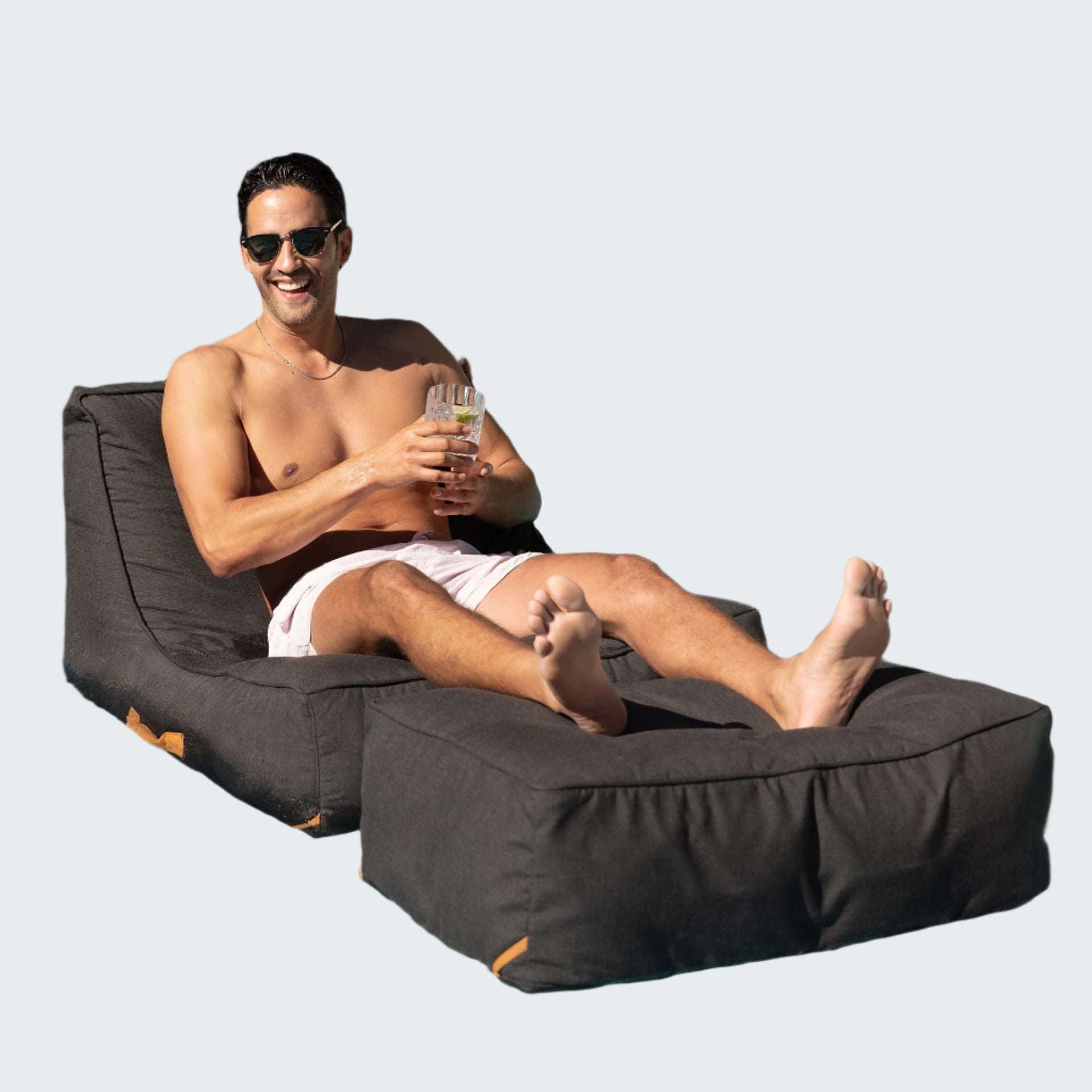 Man lounging on a floating bean bag by a pool
