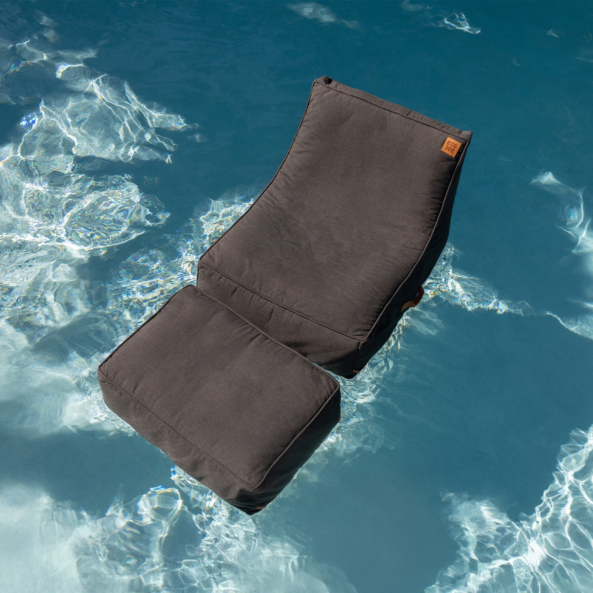 Brown cushion floating in clear blue water