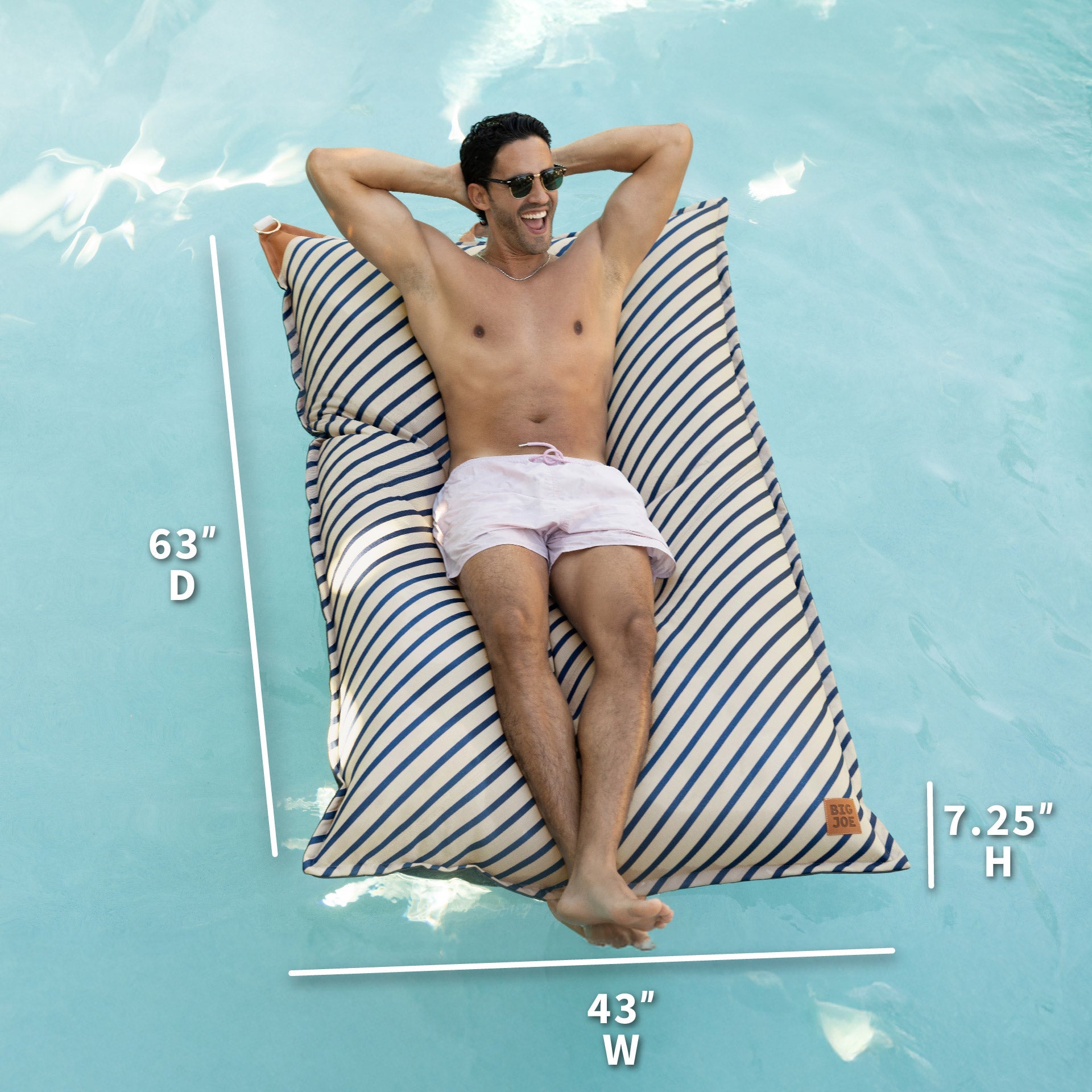 Man lying on a striped pool float with measurements displayed