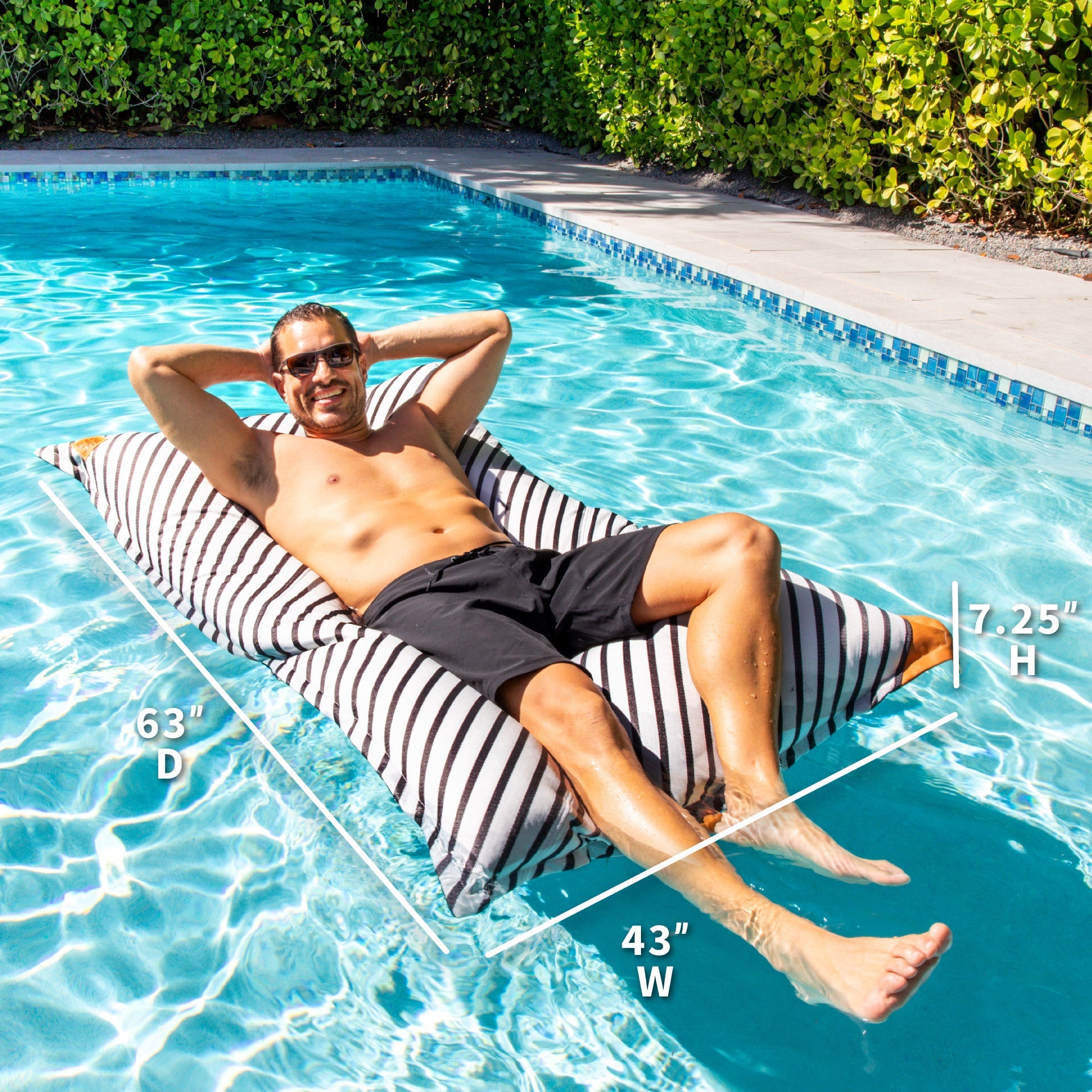Man lounging on a striped inflatable pool float in a pool with measurements displayed.